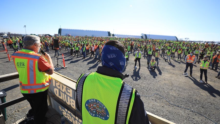 Large group assembly wearing DPR safety vests