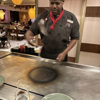 A chef cooking while wearing a branded Jia Asian coat