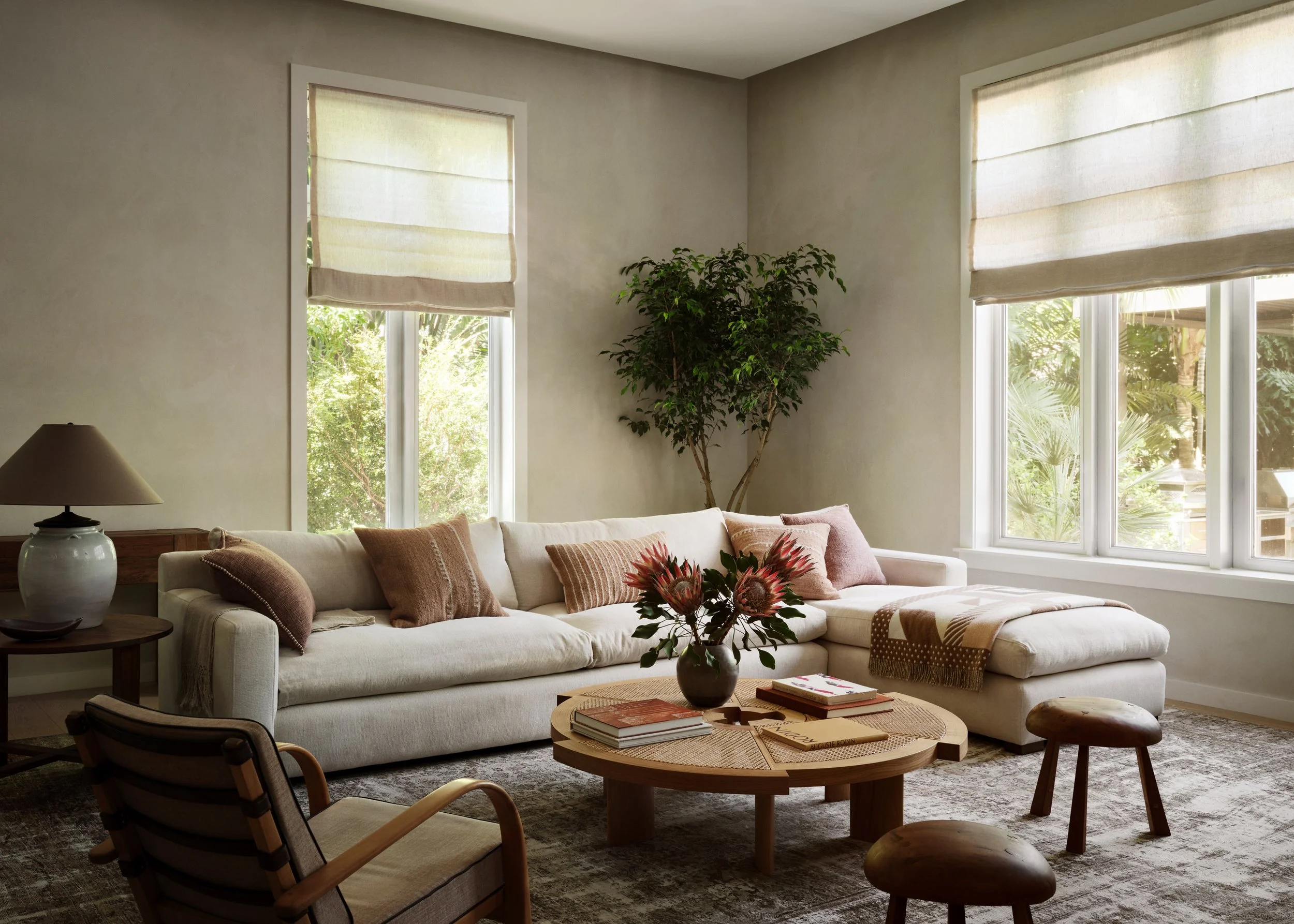 View of another seating area, L-shaped sofa, round coffee table, decor.