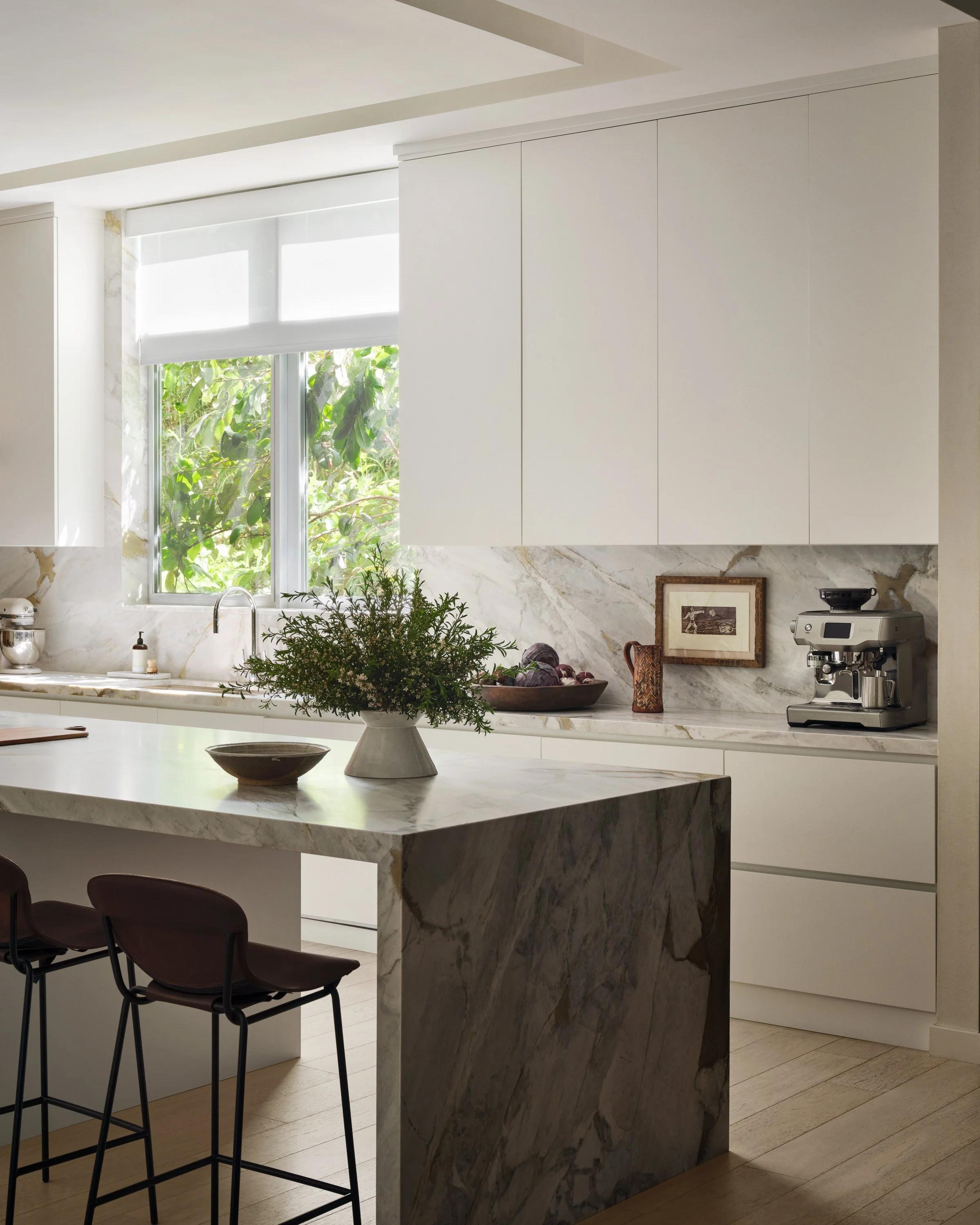 View of kitchen island and kitchen cabinets beyond.