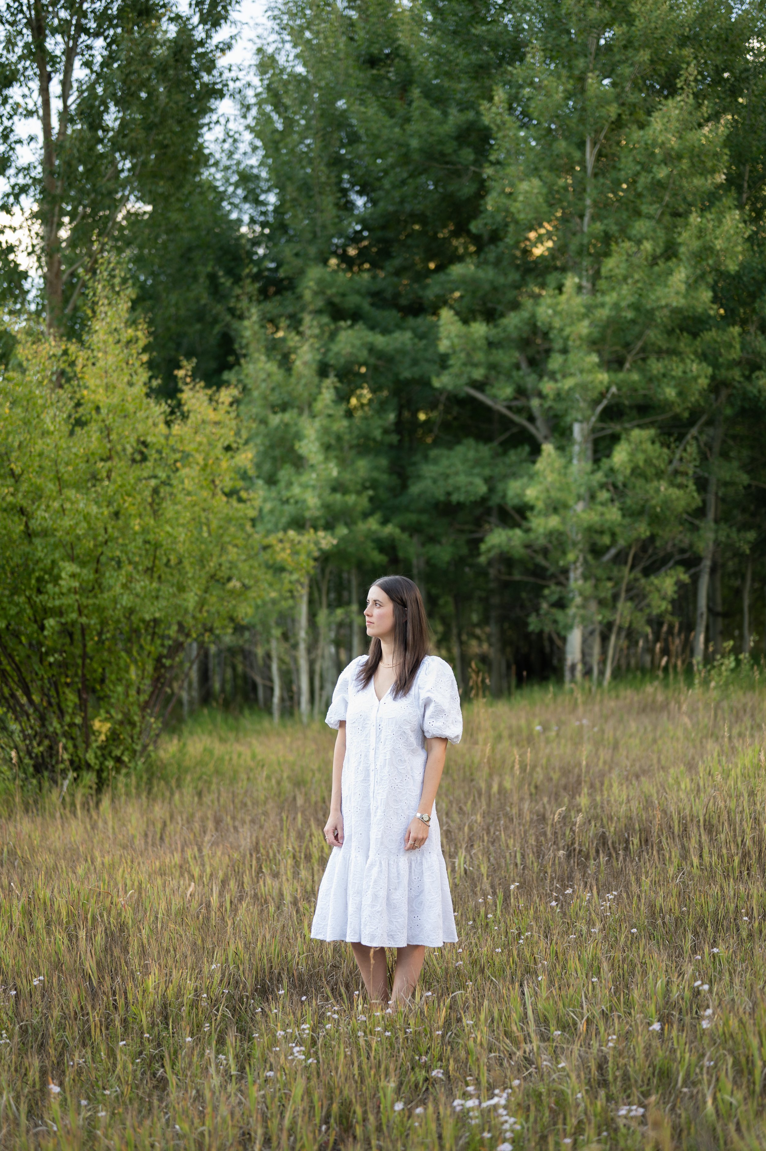 Photo of Pam in white dress with trees in the background