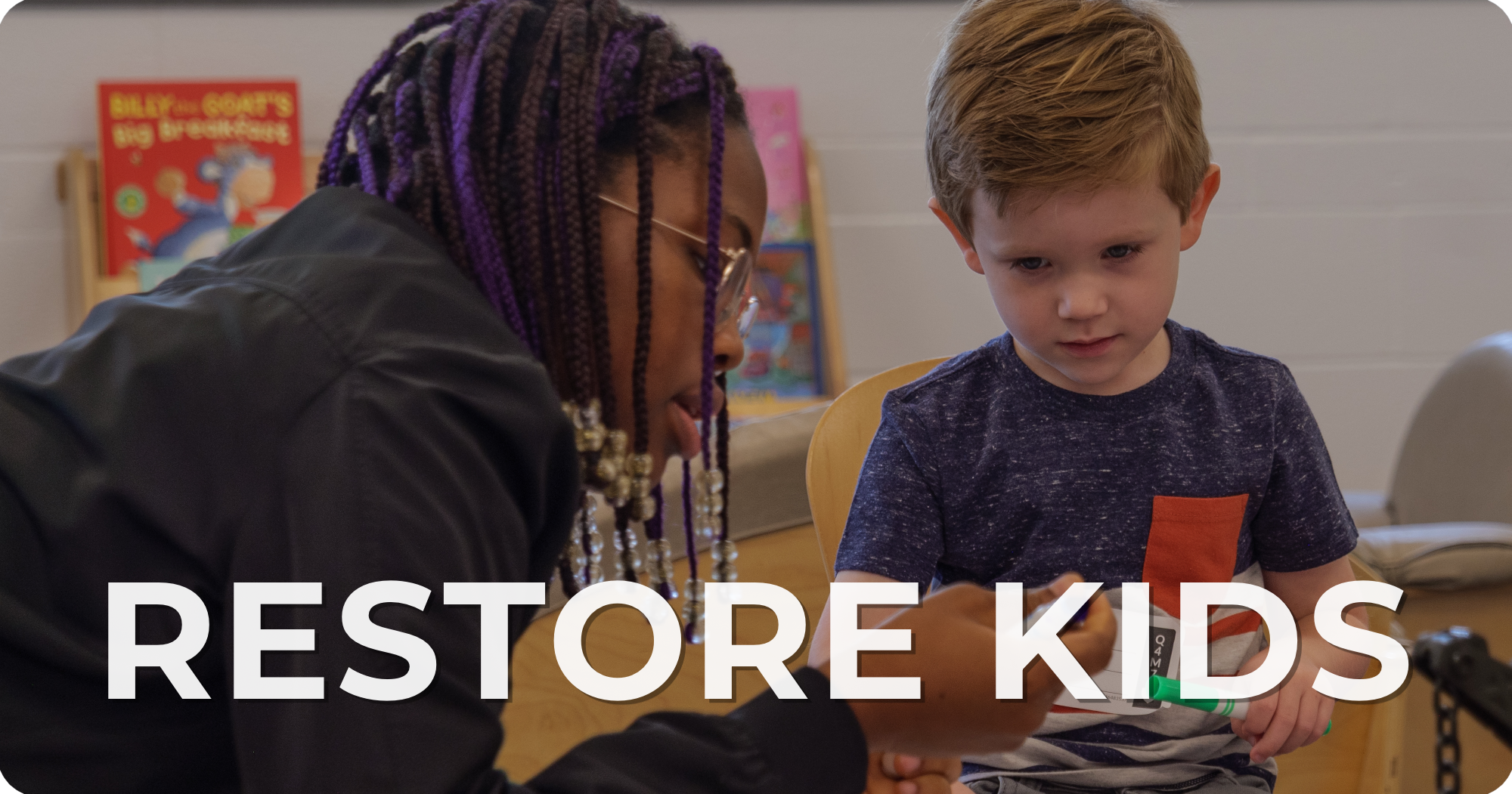 A woman with purple braided hair and glasses helping a young boy with light brown hair, who is sitting at a table, with a toy or device. Background shows colorful children's books and a white wall. Text overlay says 'RESTORE KIDS'.