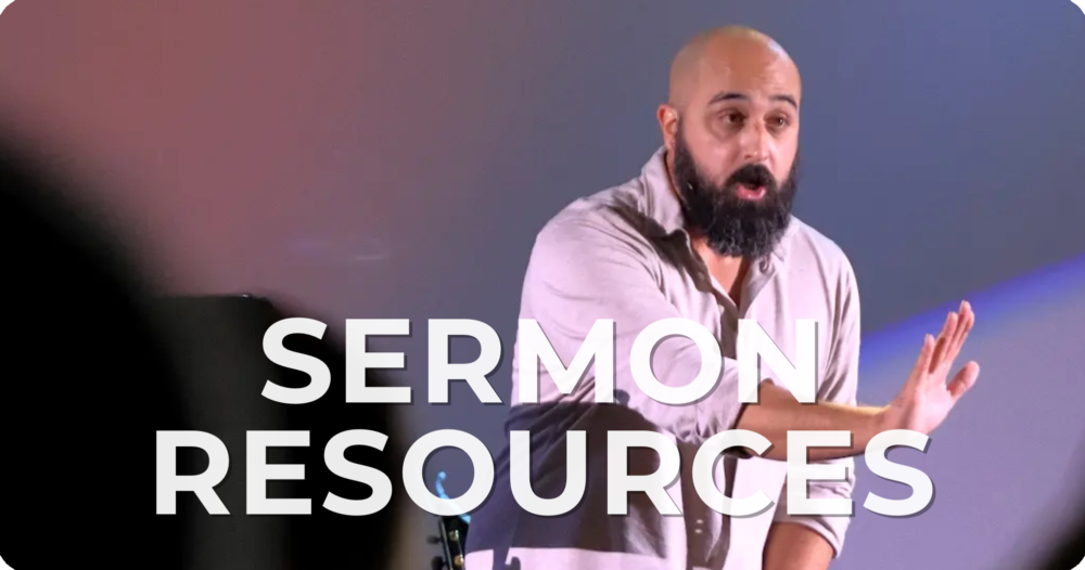 A man with a beard and bald head teaching or giving a presentation on sermon resources, with a blurred audience in the foreground.