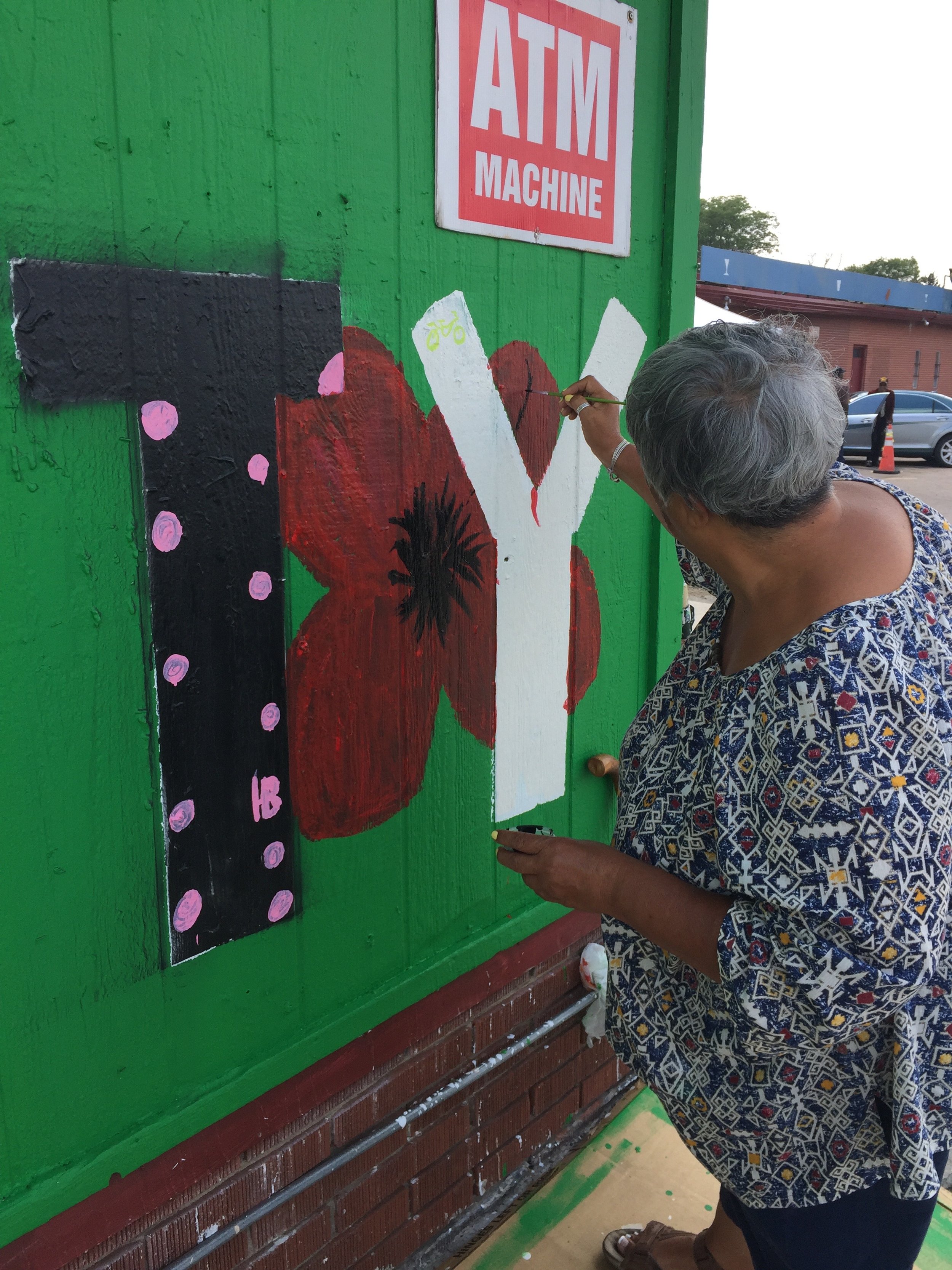 Community artist elder came out to participate in the mural creation. As a benefit of the community engagement process, neighbors get to know those they may not have met, like this artist who has a robust art career and studio in the neighborhood.