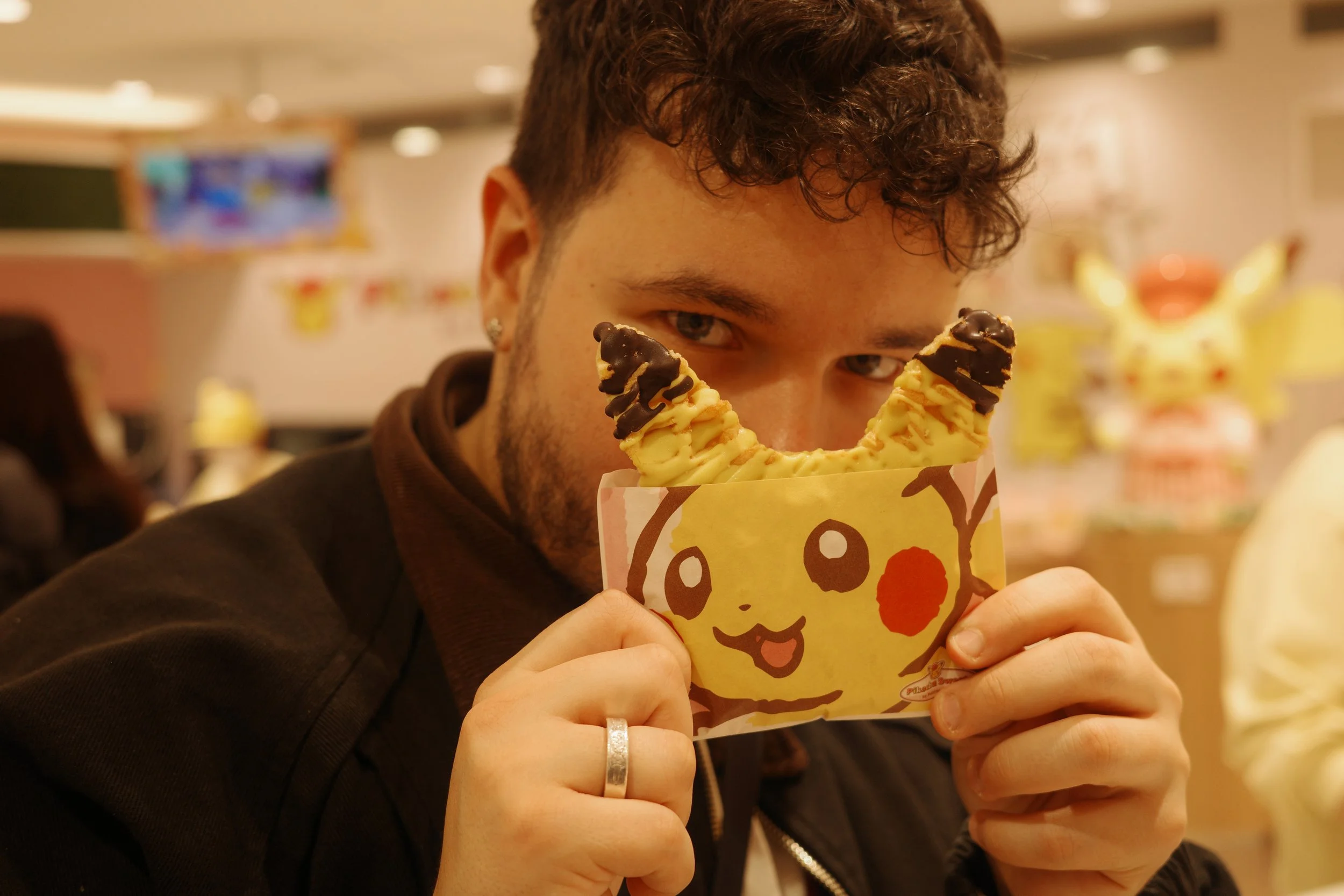 Forcing my boyfriend to pose with his pikachu waffle at the Pokemon cafe