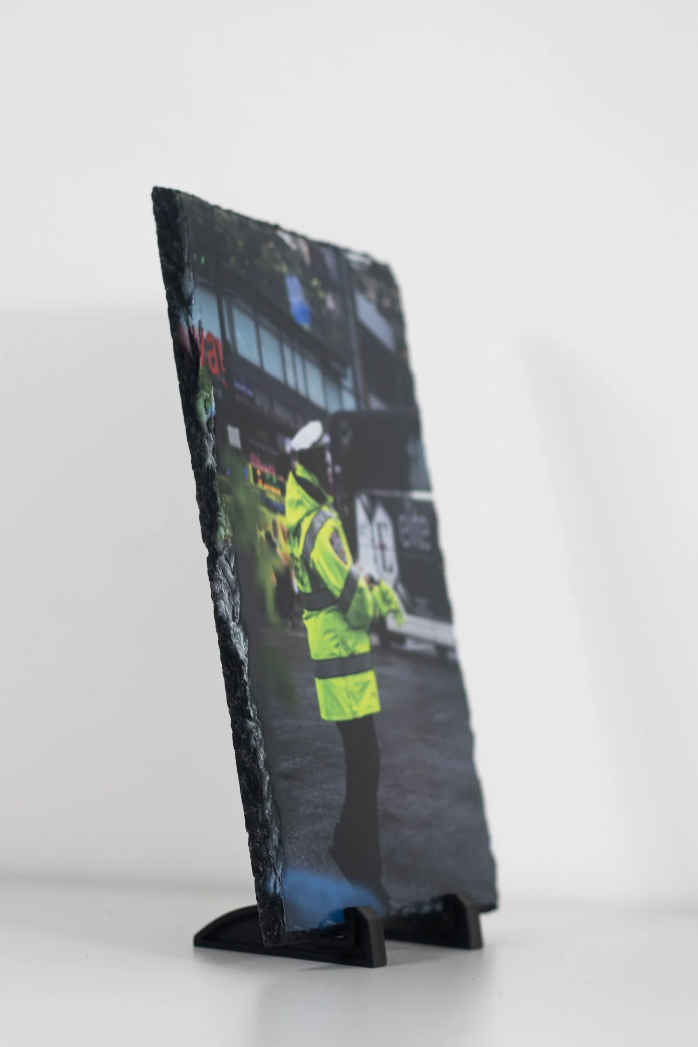 Photo of a photo on a black stand showing a police officer in high-visibility clothing near a police vehicle