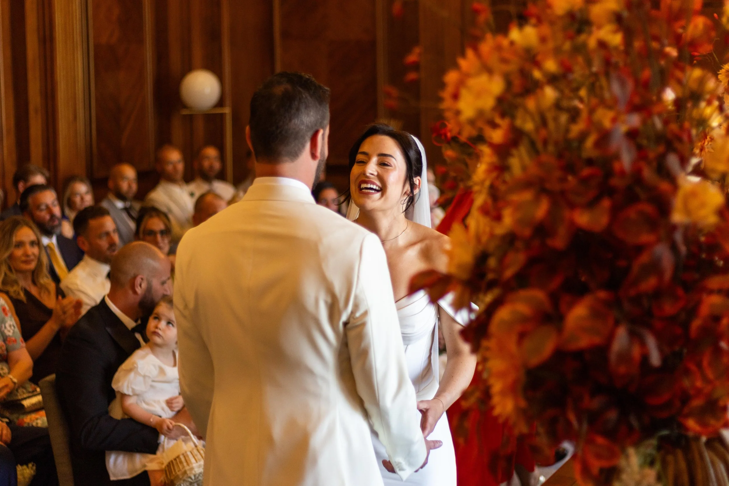 A bride and groom exchanging vows during a wedding ceremony with guests watching.
