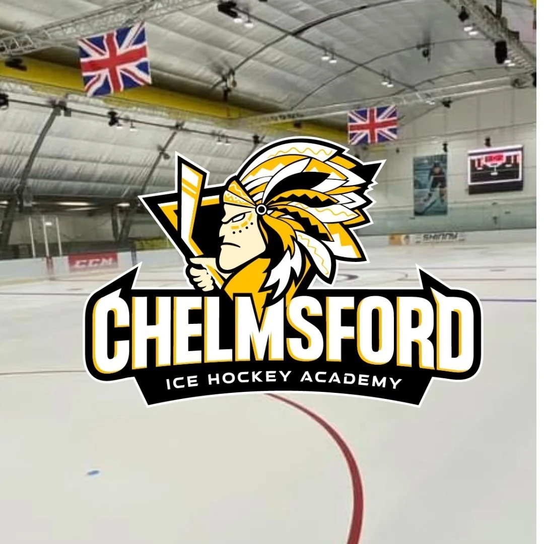 Indoor ice hockey rink at Chelmsford Ice Hockey Academy with flags hanging from the ceiling.