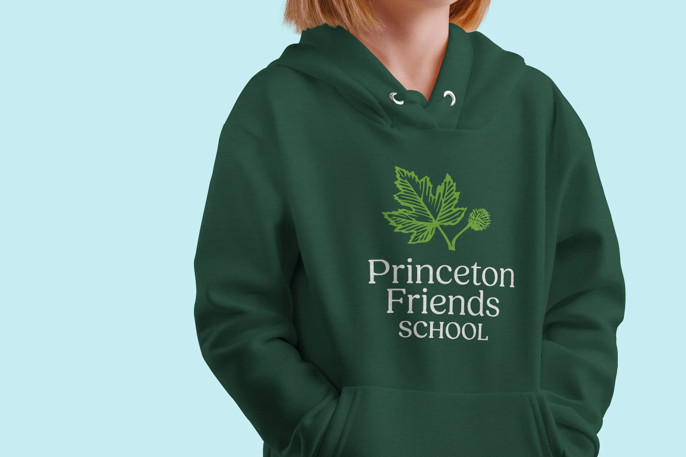 Girl wearing a dark green hoodie with Princeton Friends School logo.