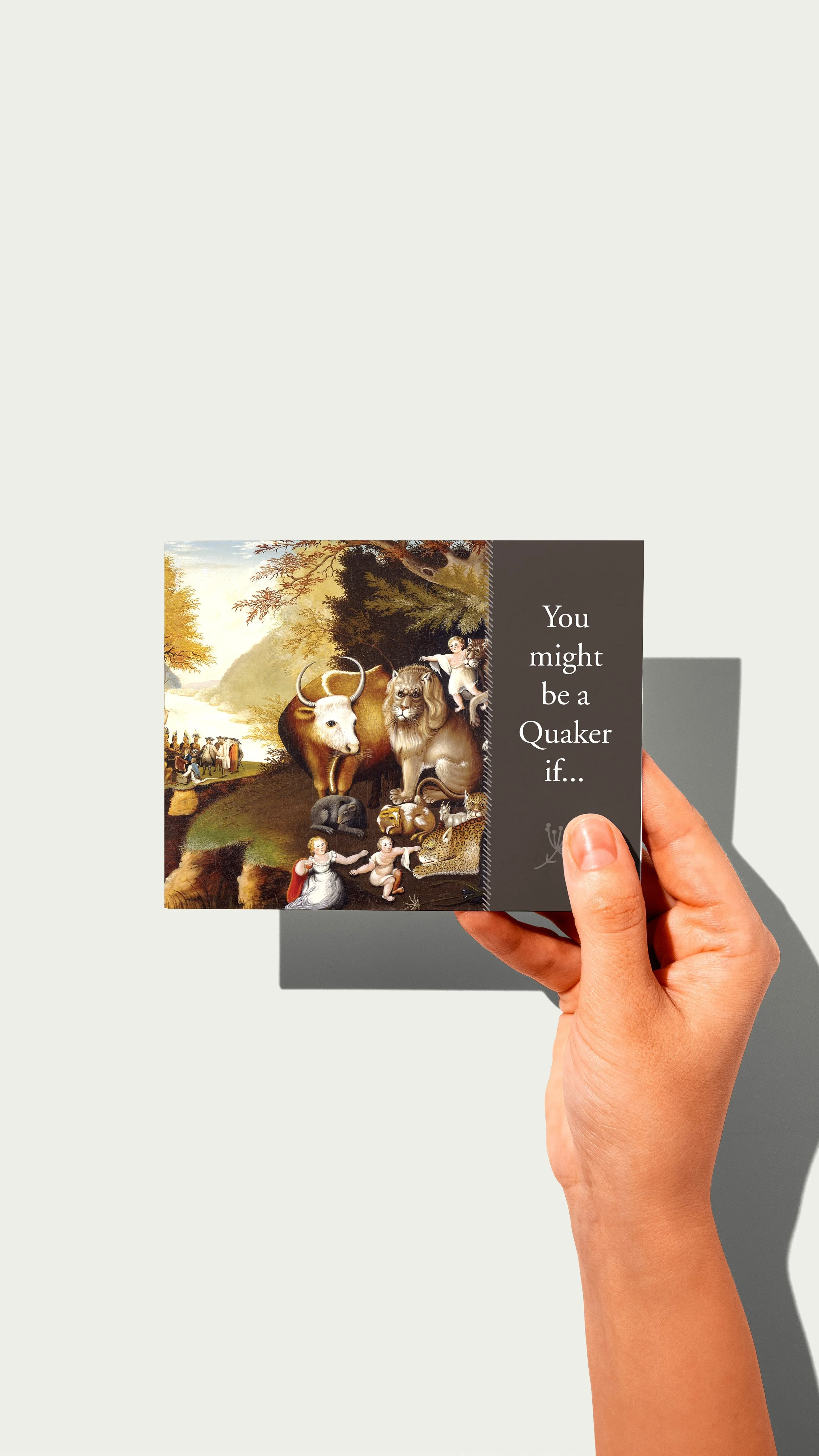 Hand holding Bucks Quarter postcard with Peaceable Kingdom painting on left and the phrase You might be a Quaker if...