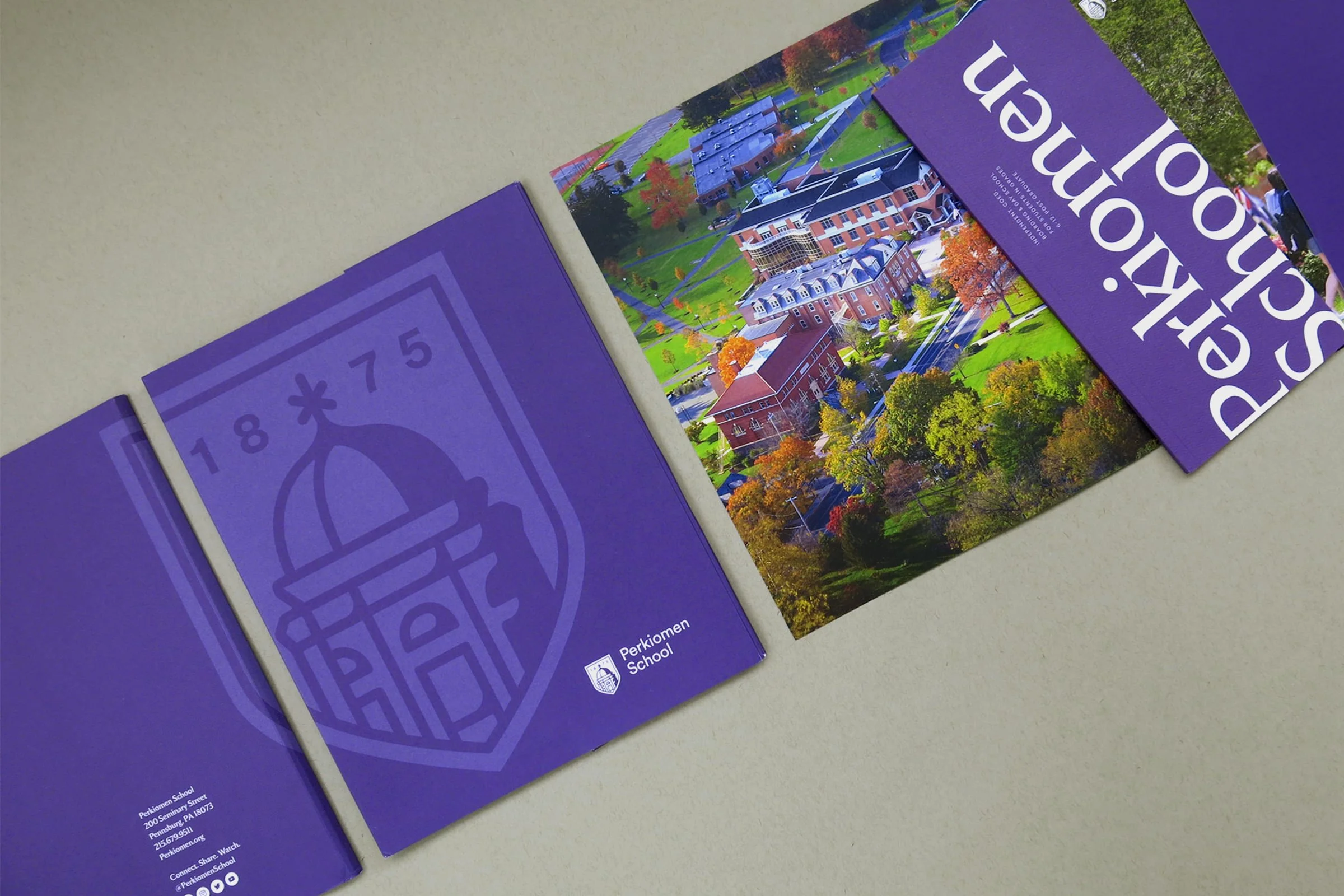 Perkiomen School viewbook with bright purple cover and folder. Inside of folder features drone photo of campus on inside of a folder and cropped logo on cover.