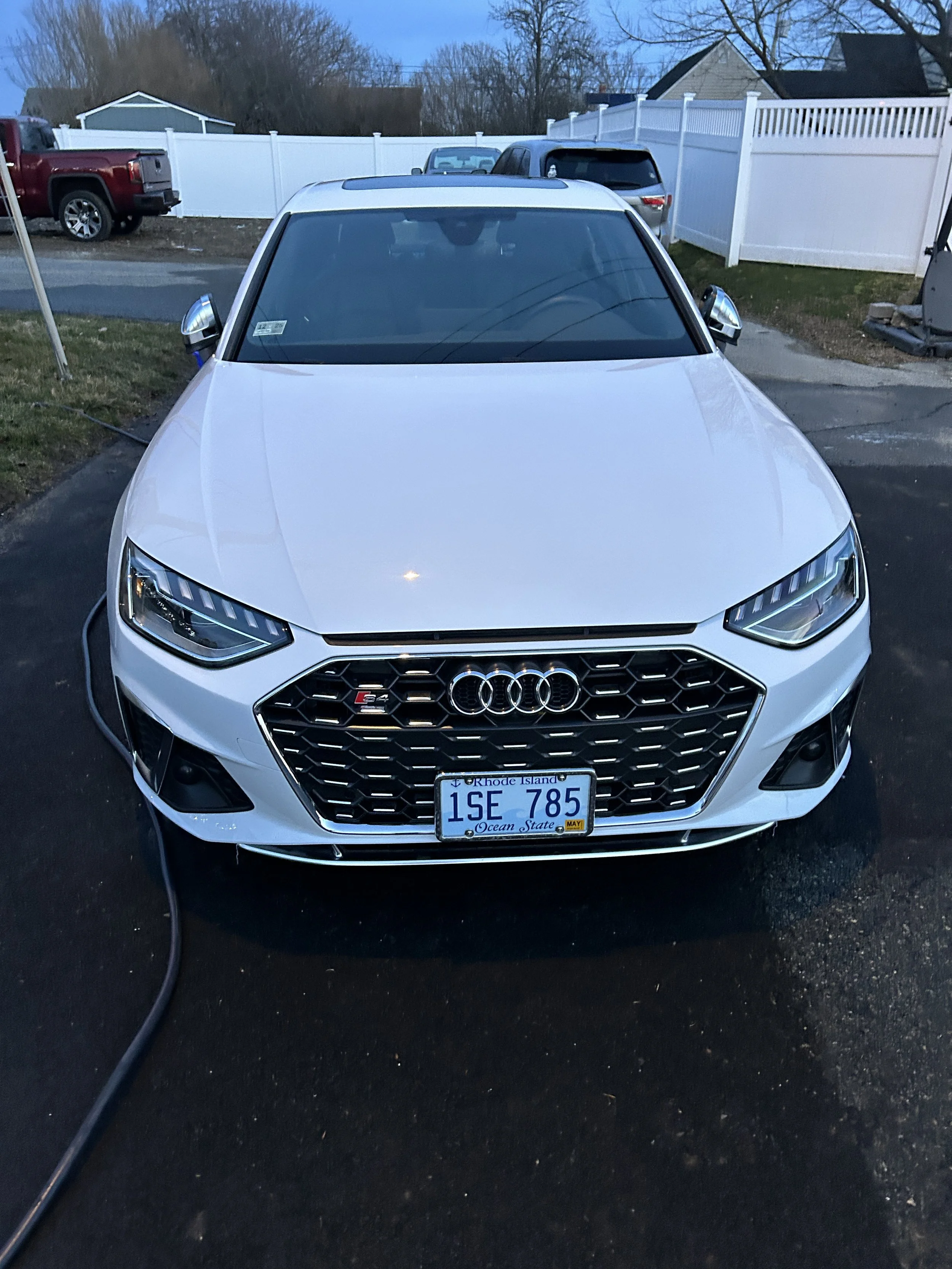 Front view of a white Audi car parked on a driveway with Rhode Island license plate.
