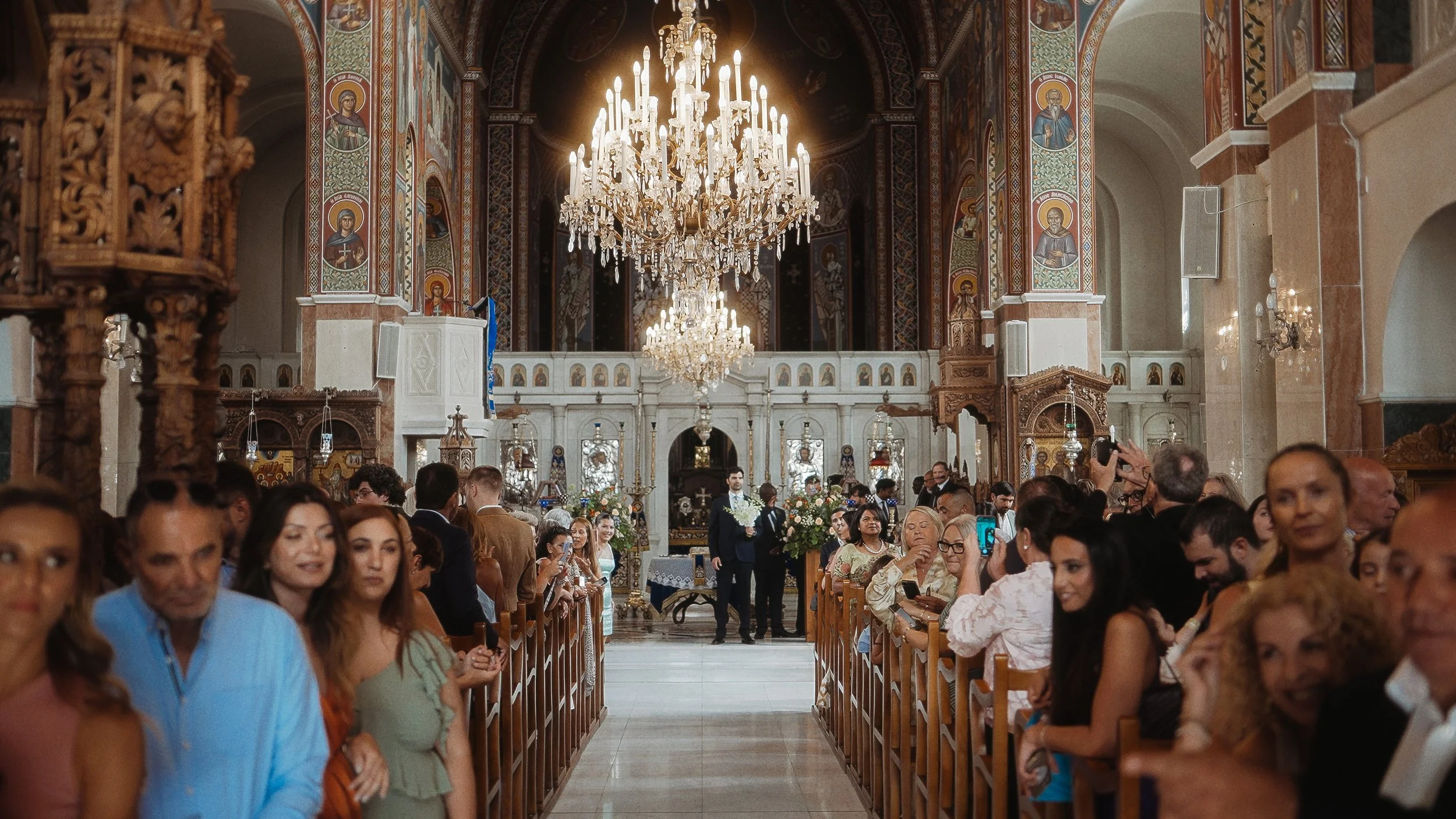 Groom walking down the aisle inside Ayioi Omoloyites church, Greek Orthodox wedding ceremony Nicosia Cyprus, Red Lens Films
