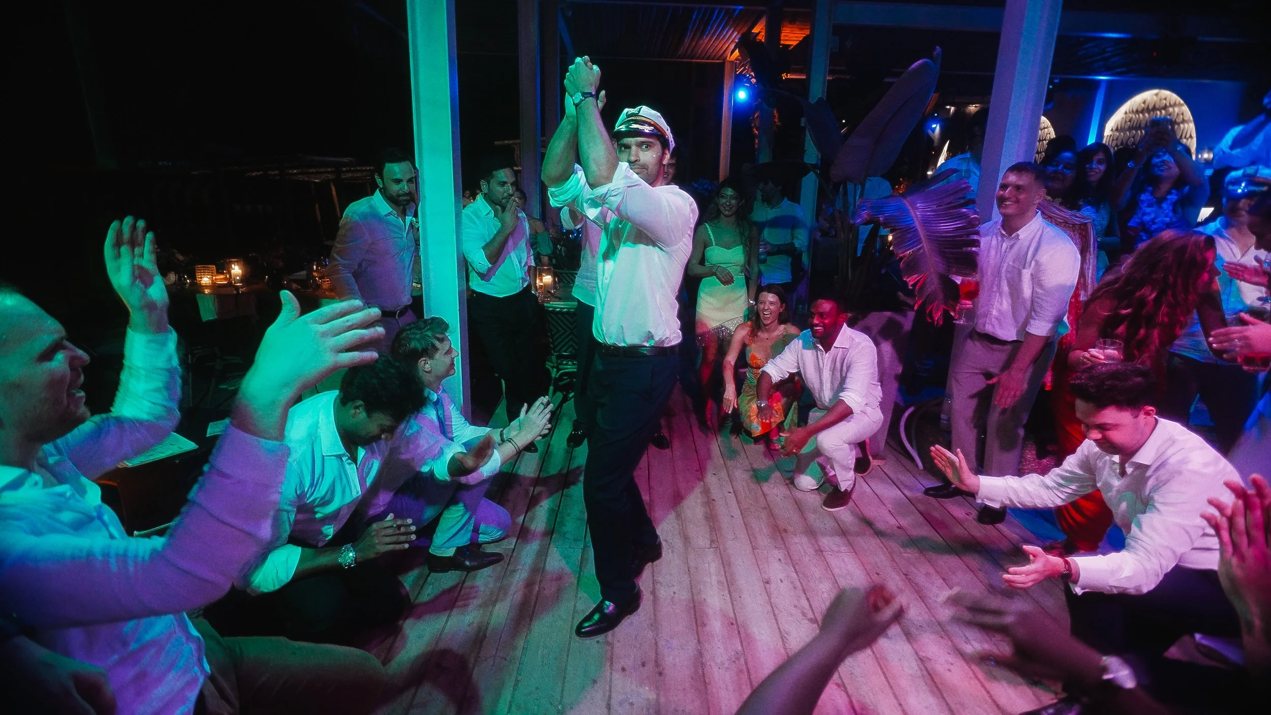 Groom performing zeimbekiko surrounded by cheering guests, wedding reception Captain's Cabin Lady's Mile Limassol, Red Lens Films