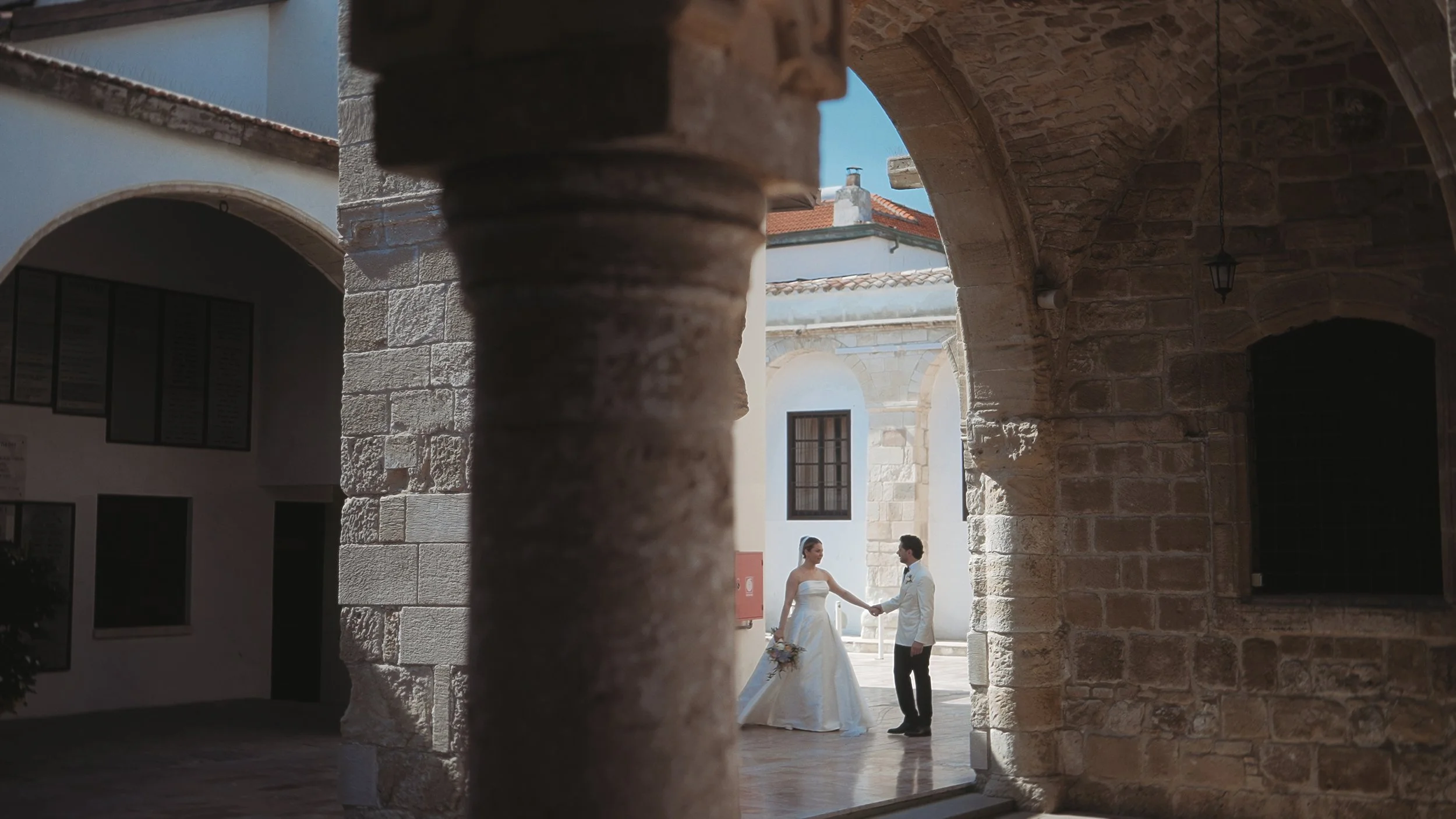 8	Bride and groom holding hands in the stone courtyard of Saint Lazarus Church Larnaca, Red Lens Films