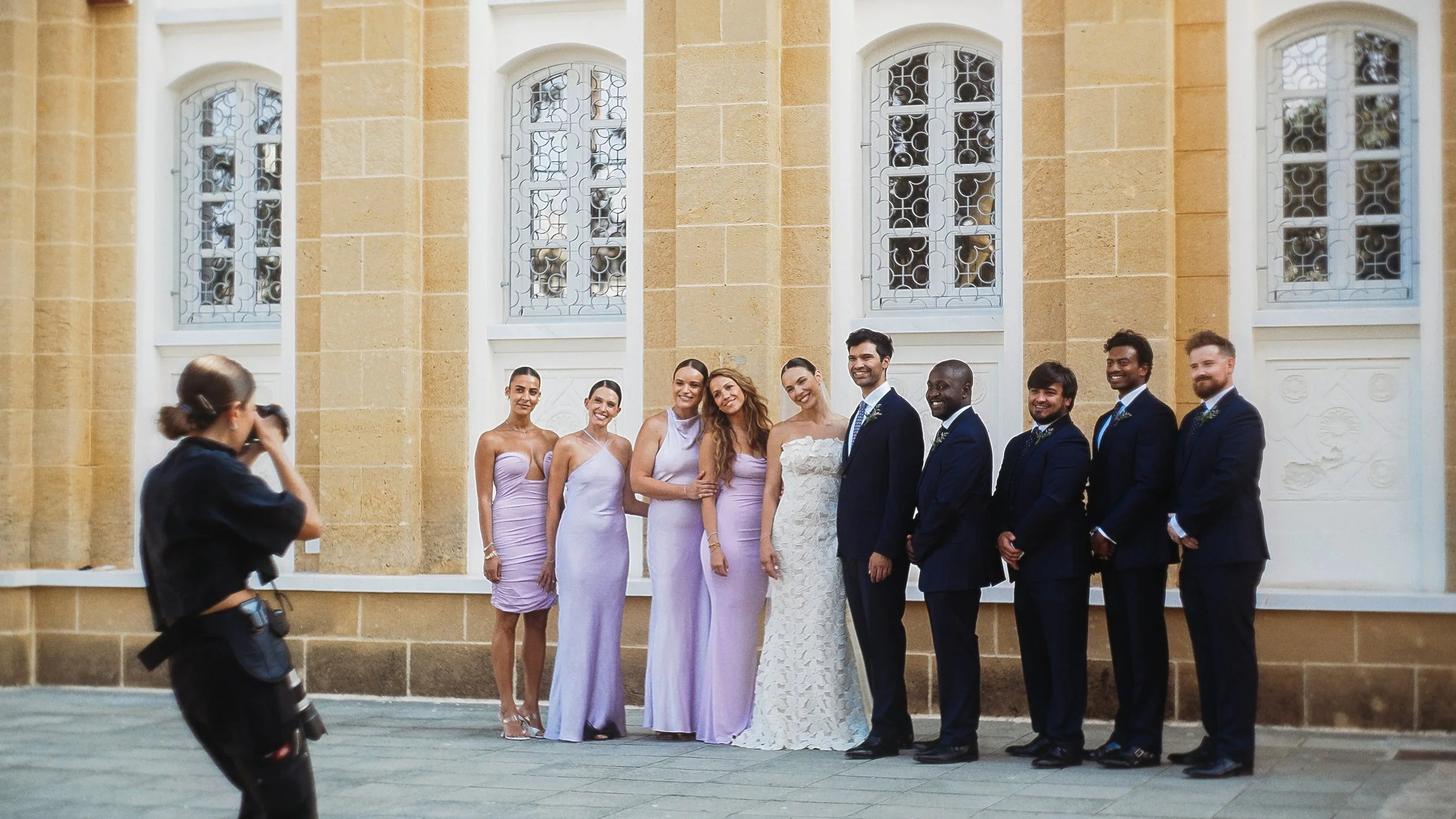 Bride and groom with bridesmaids and groomsmen outside Ayioi Omoloyites church, Nicosia Cyprus, Red Lens Films
