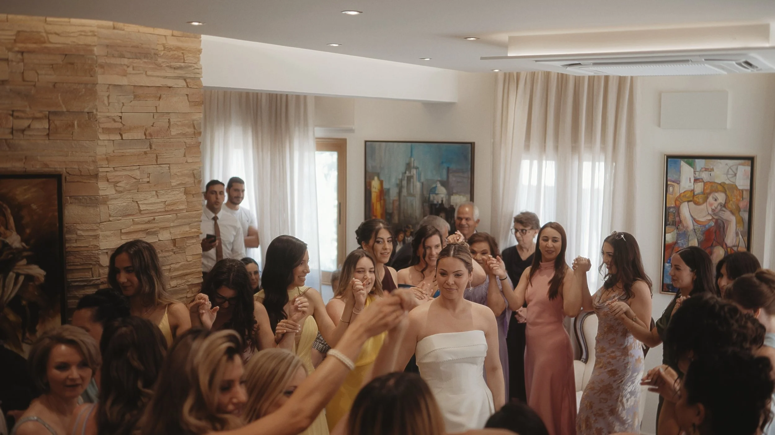 Bride Evgenia dancing in a circle with friends at her Cypriot wedding preparation in Larnaca, Red Lens Films