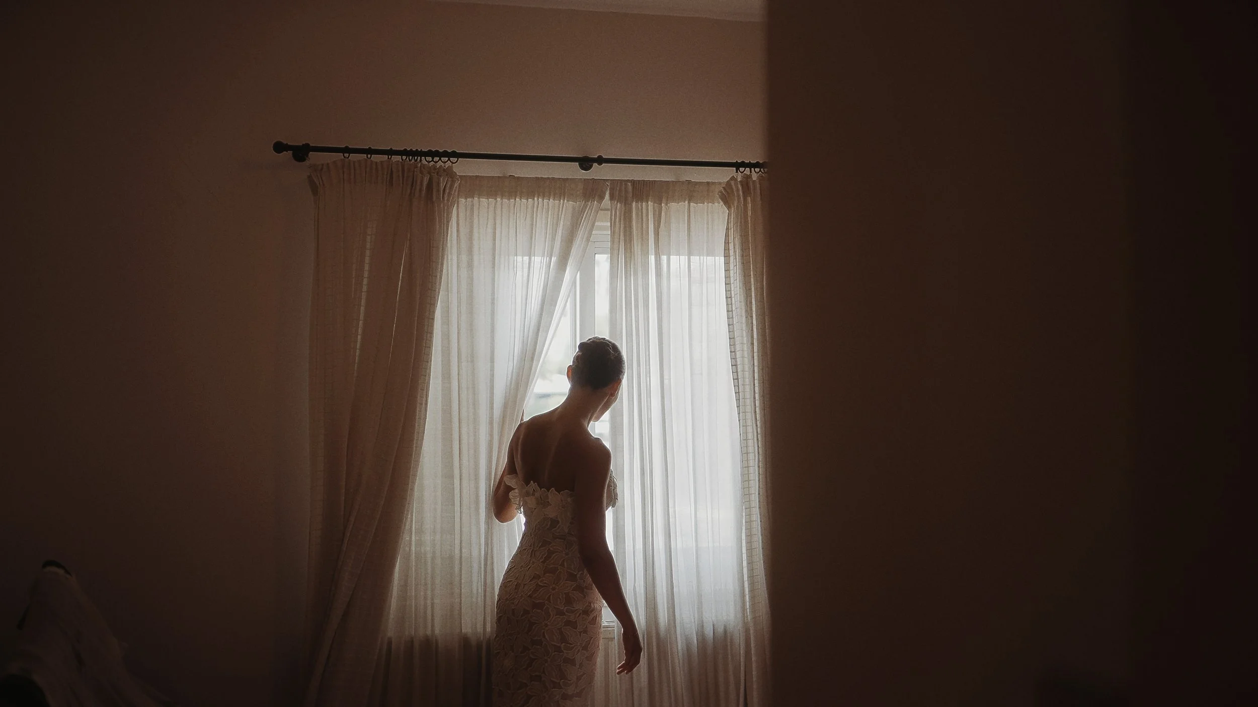 Bride silhouette at window in lace wedding dress during morning preparations, Nicosia Cyprus, Red Lens Films