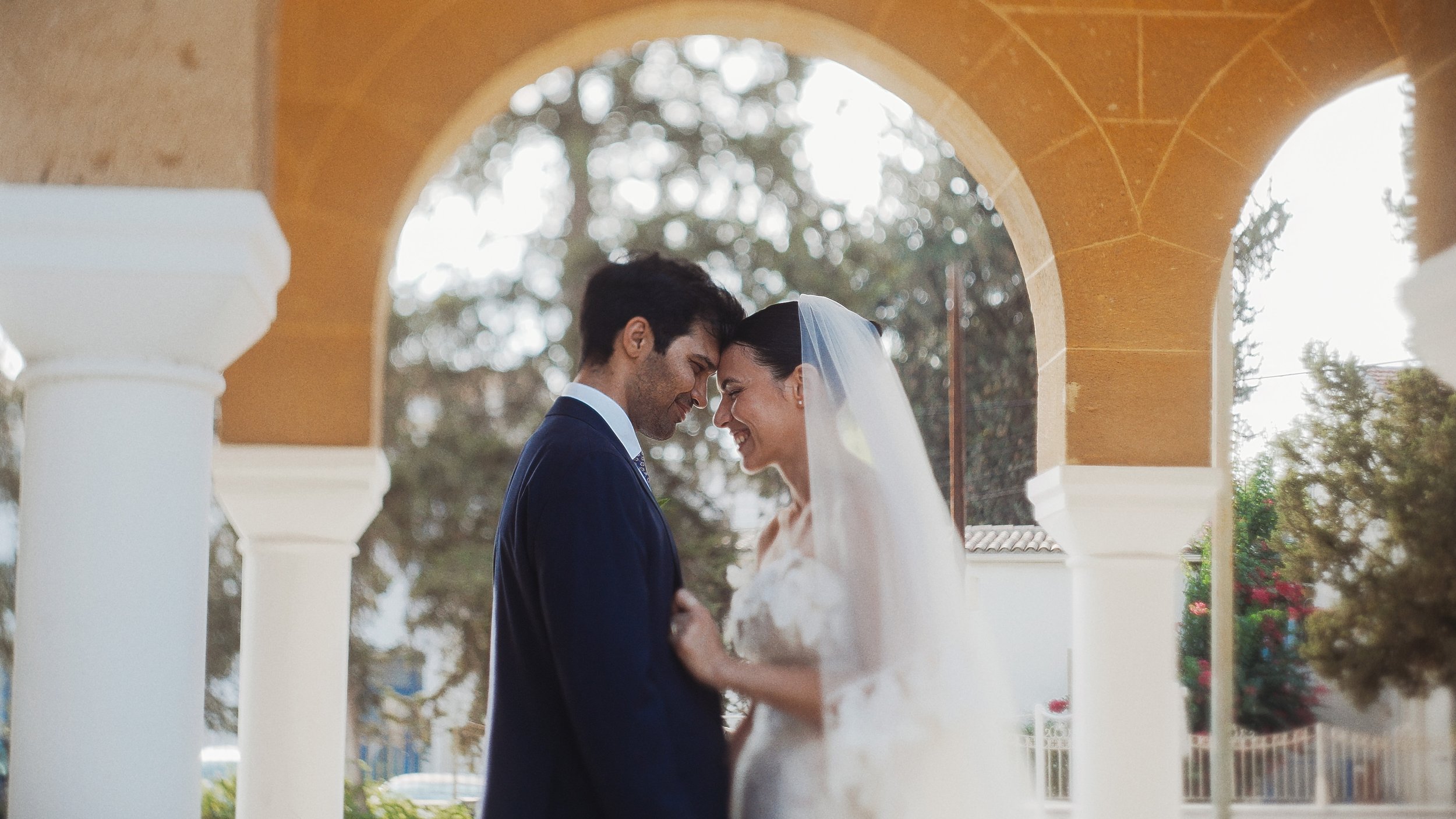 Bride and groom forehead to forehead laughing outside church, Ayioi Omoloyites Nicosia, Red Lens Films