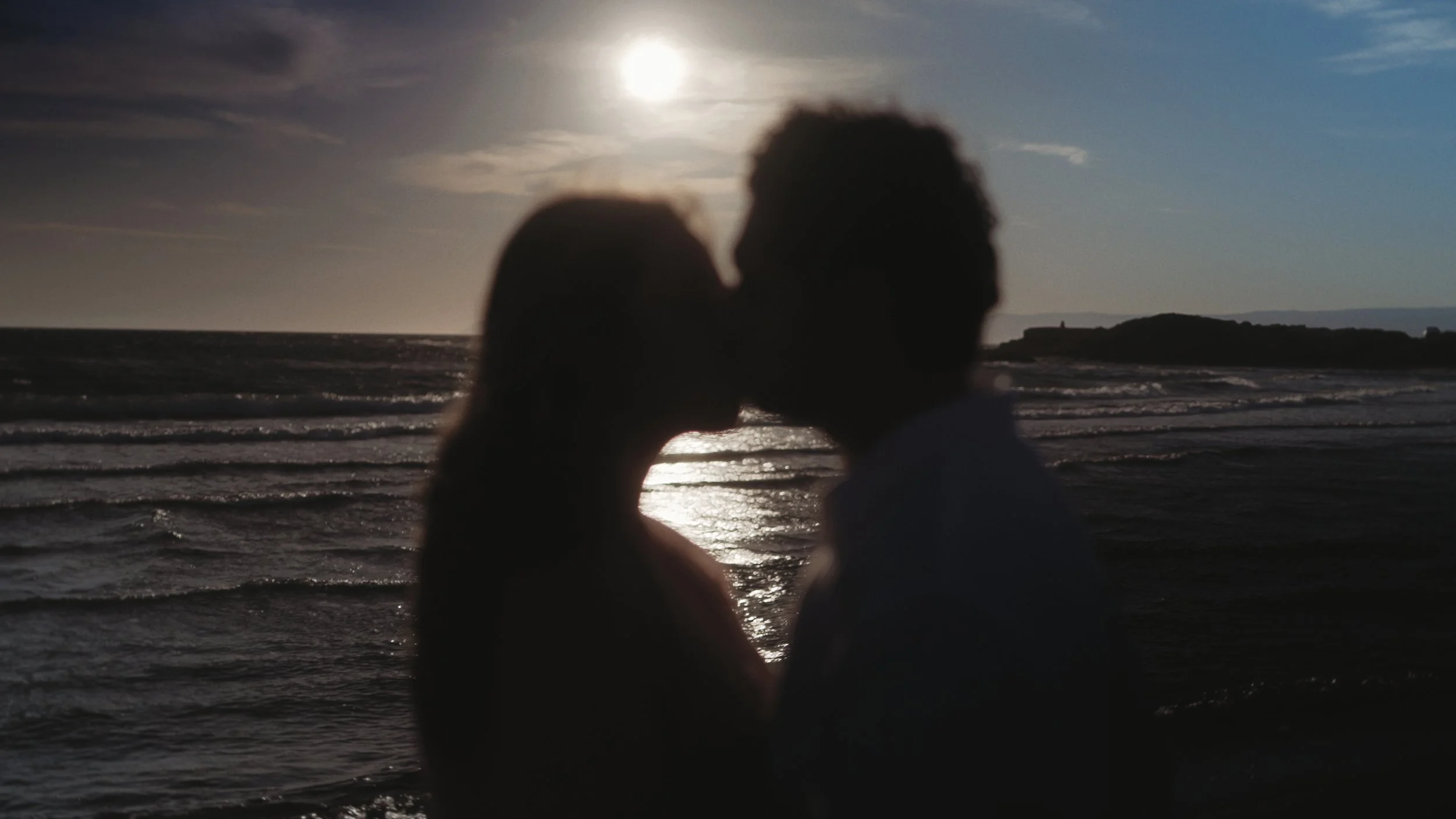 Silhouette of Evgenia and Geri kissing at sunset by the sea in Akrotiri Cyprus, Red Lens Films