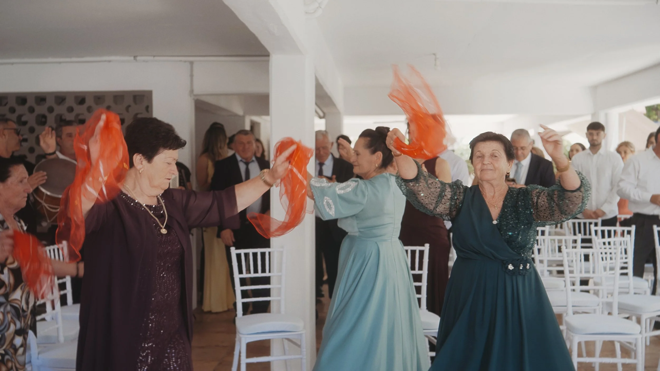 Family dancing with orange scarves during the Albanian groom preparation in Larnaca, Cyprus, Red Lens Films
