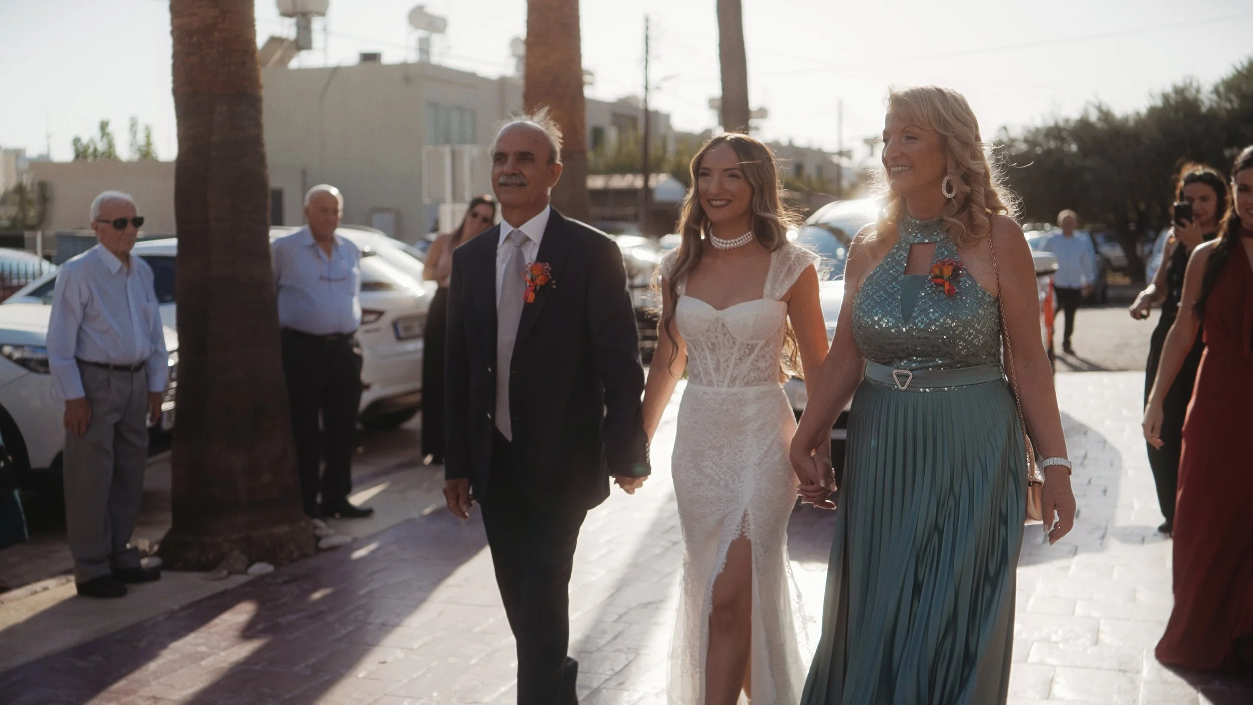 Bride walking to church with parents in afternoon sunlight, Ayios Stylianos Church Agios Athanasios Cyprus, Red Lens Films