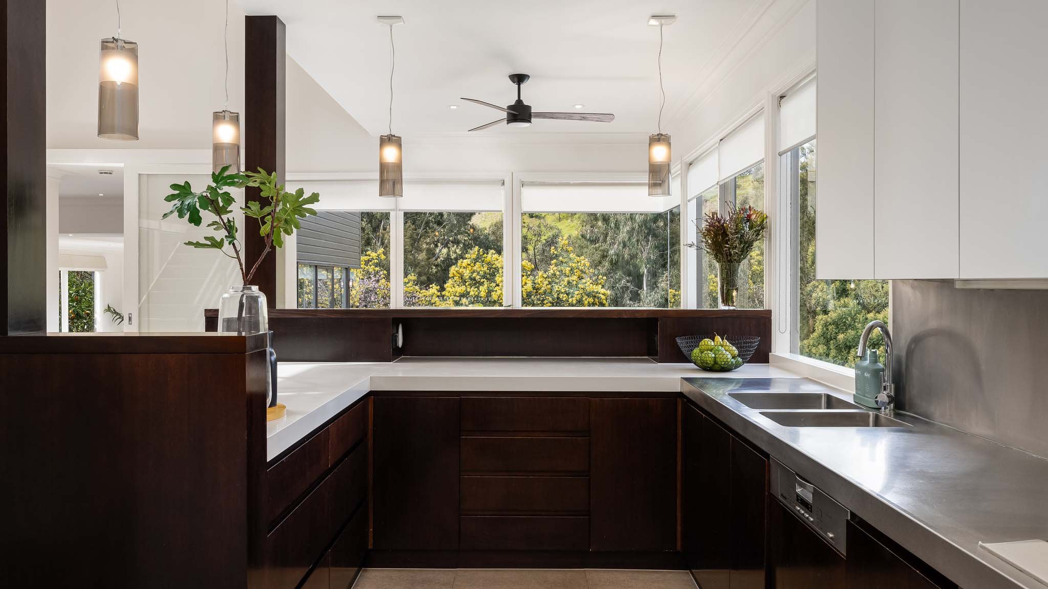 Culinary Harmony: Explore a U-shaped kitchen Where the Bar Seamlessly Links to the Dining Area, All While Concealing a Vast Pantry Beyond.
