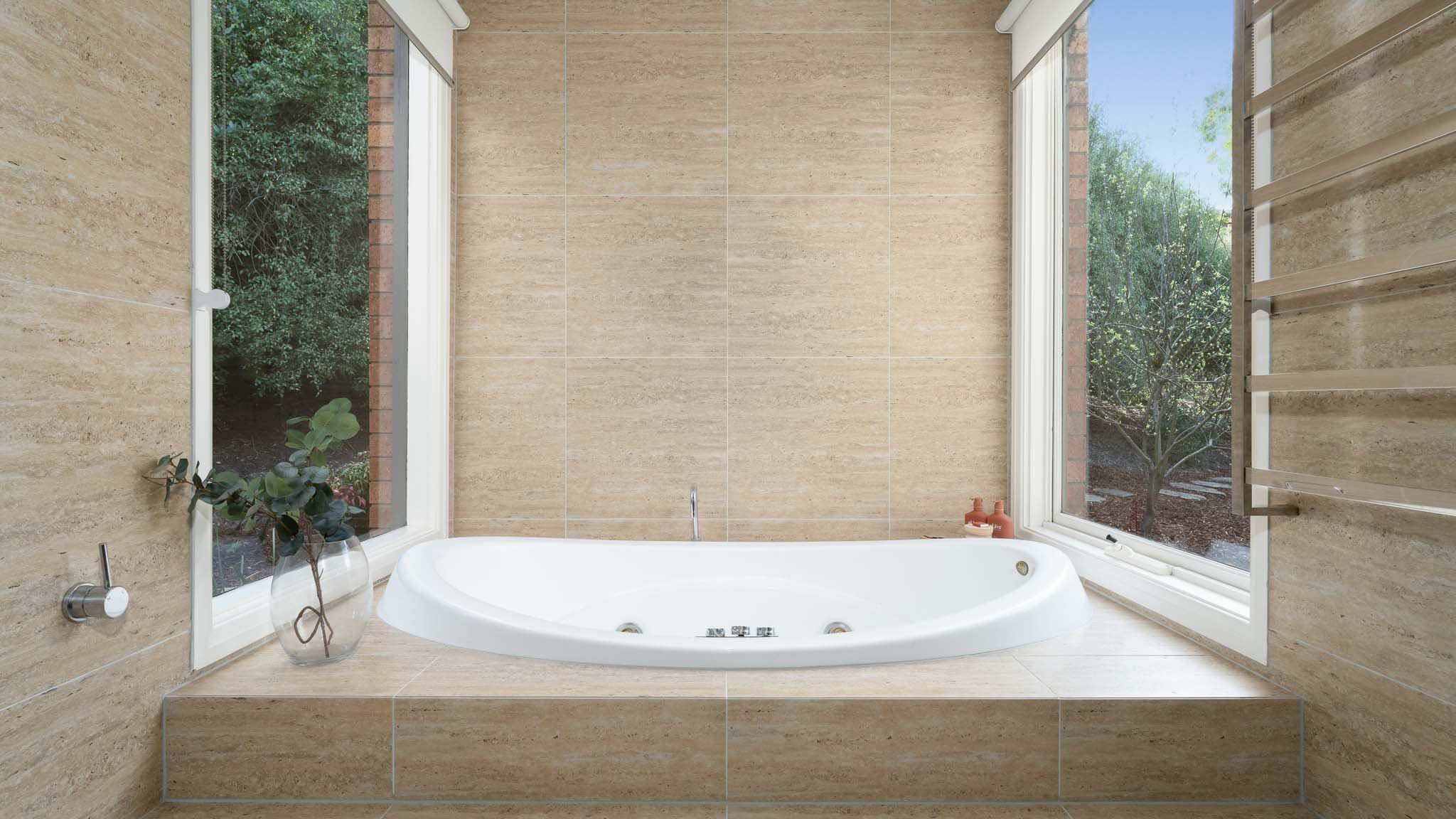 Bathing in Tranquility: Immerse Yourself in Serenity within Our Expansive Tub, Embraced by Subtle Tones and Bathed in Natural Light from Generous Windows.