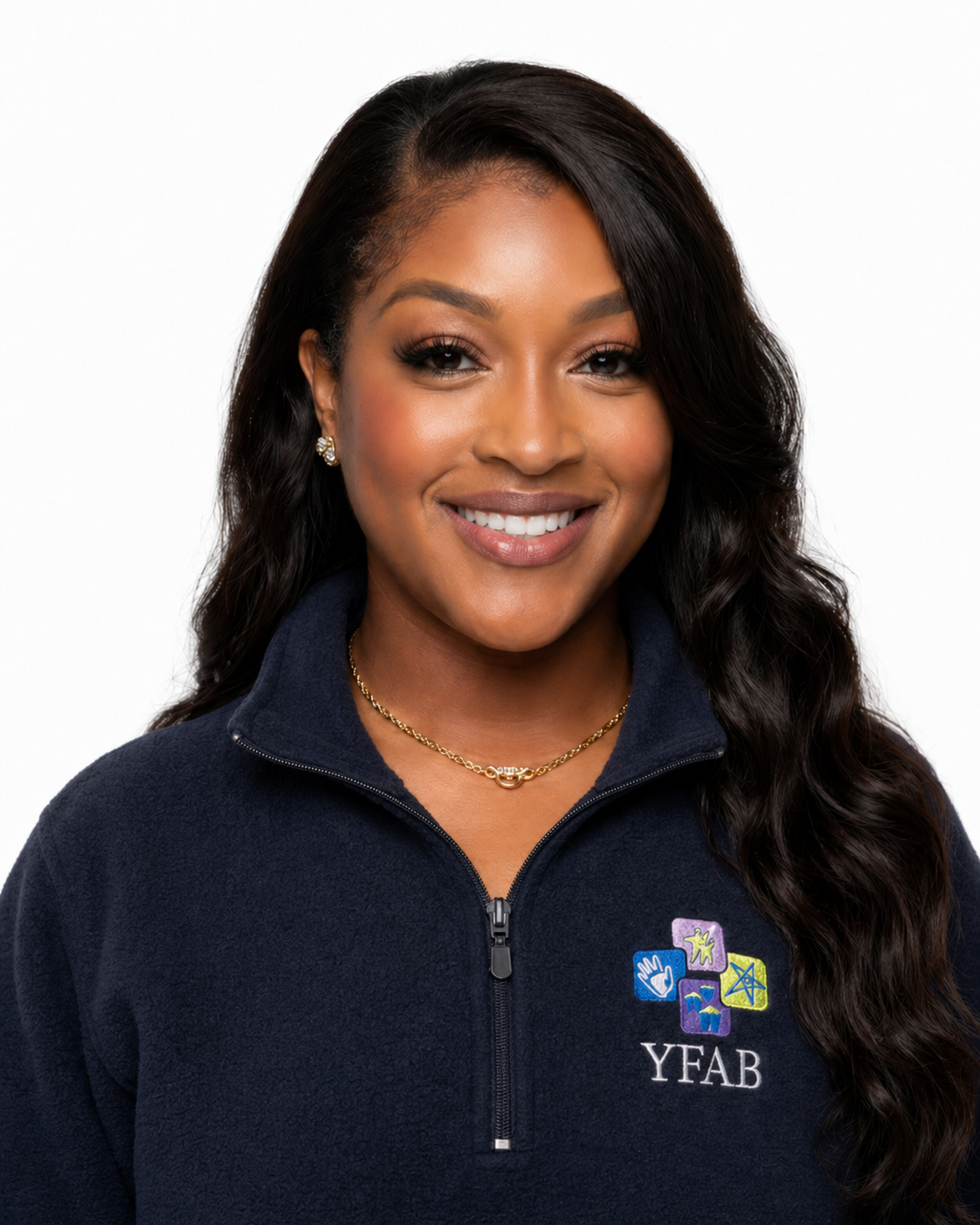 A smiling woman with long dark hair wearing a navy blue jacket with an embroidered logo that reads "YFAB" and features colorful icons, jewelry, and a white background.