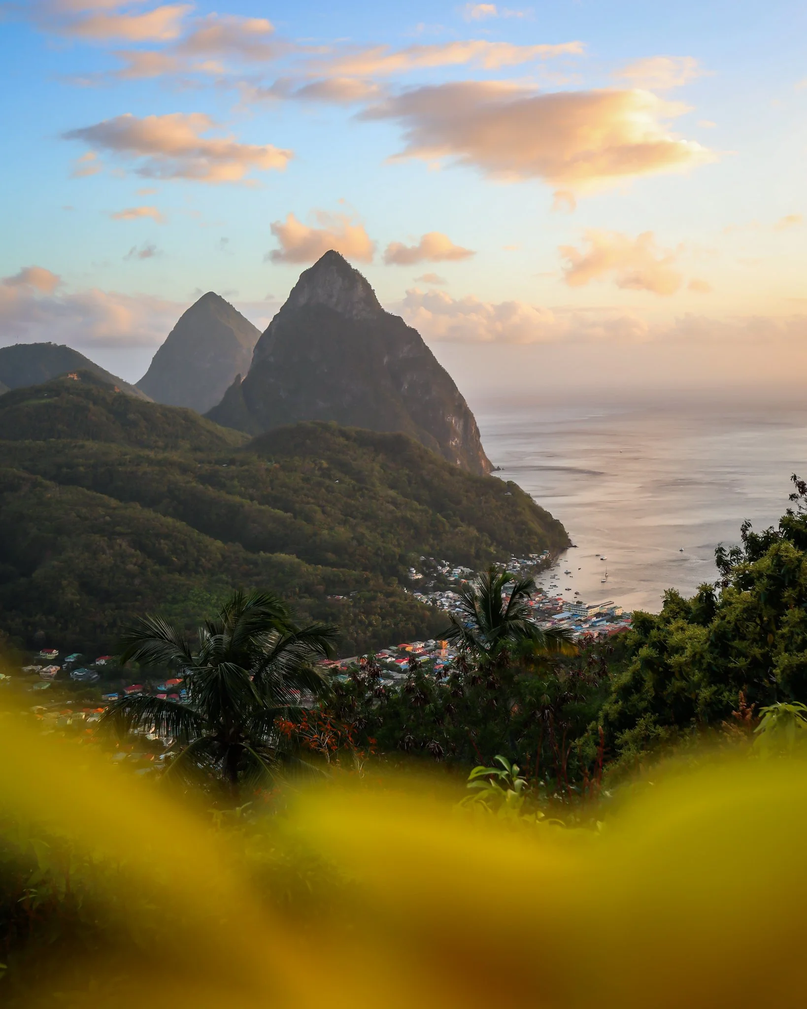 Landscape with mountains, a town along the coast, and a cloudy sky at sunrise or sunset