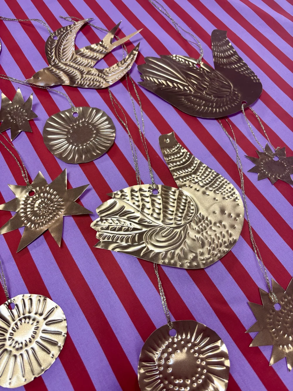 Gold embossed bird and star ornaments on a striped cloth