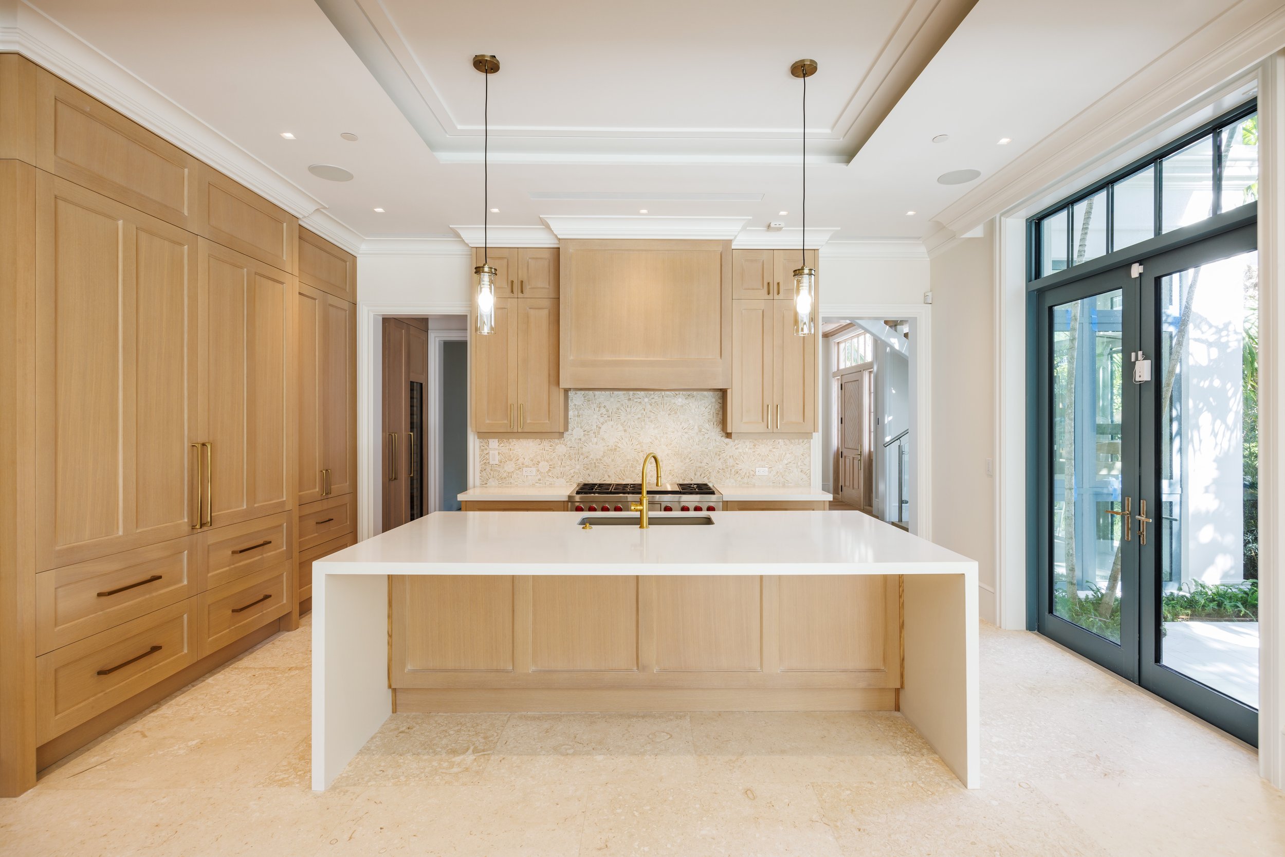 Modern kitchen with rift-sawn white oak cabinetry and panels for appliances.