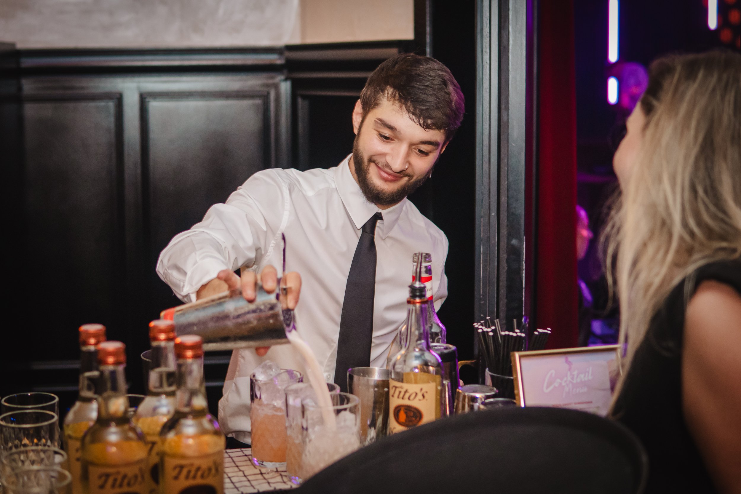 Private mixologist creating premium cocktail experience at elegant house party.