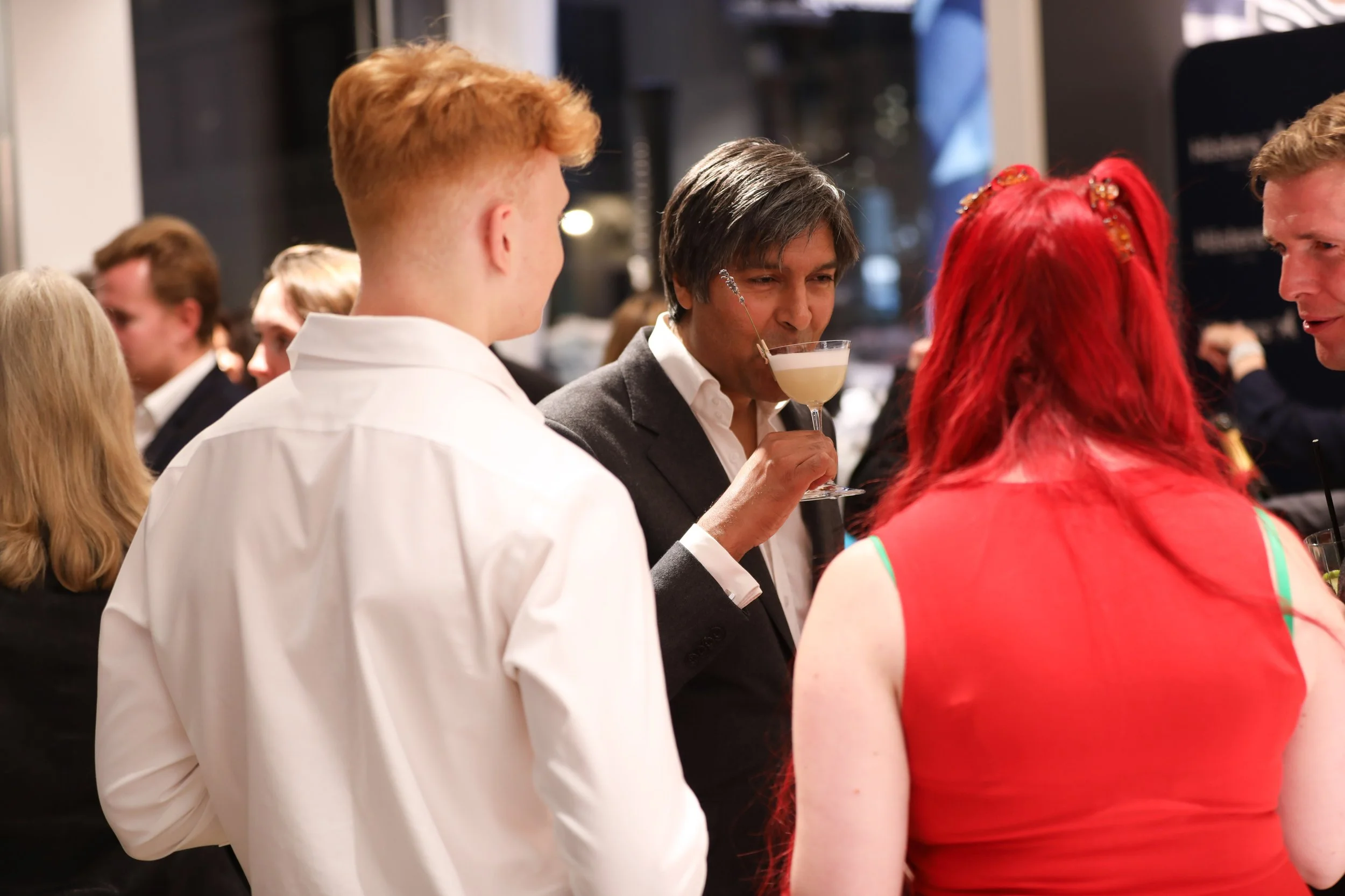 Guests networking at luxury cocktail bar during corporate product launch event.