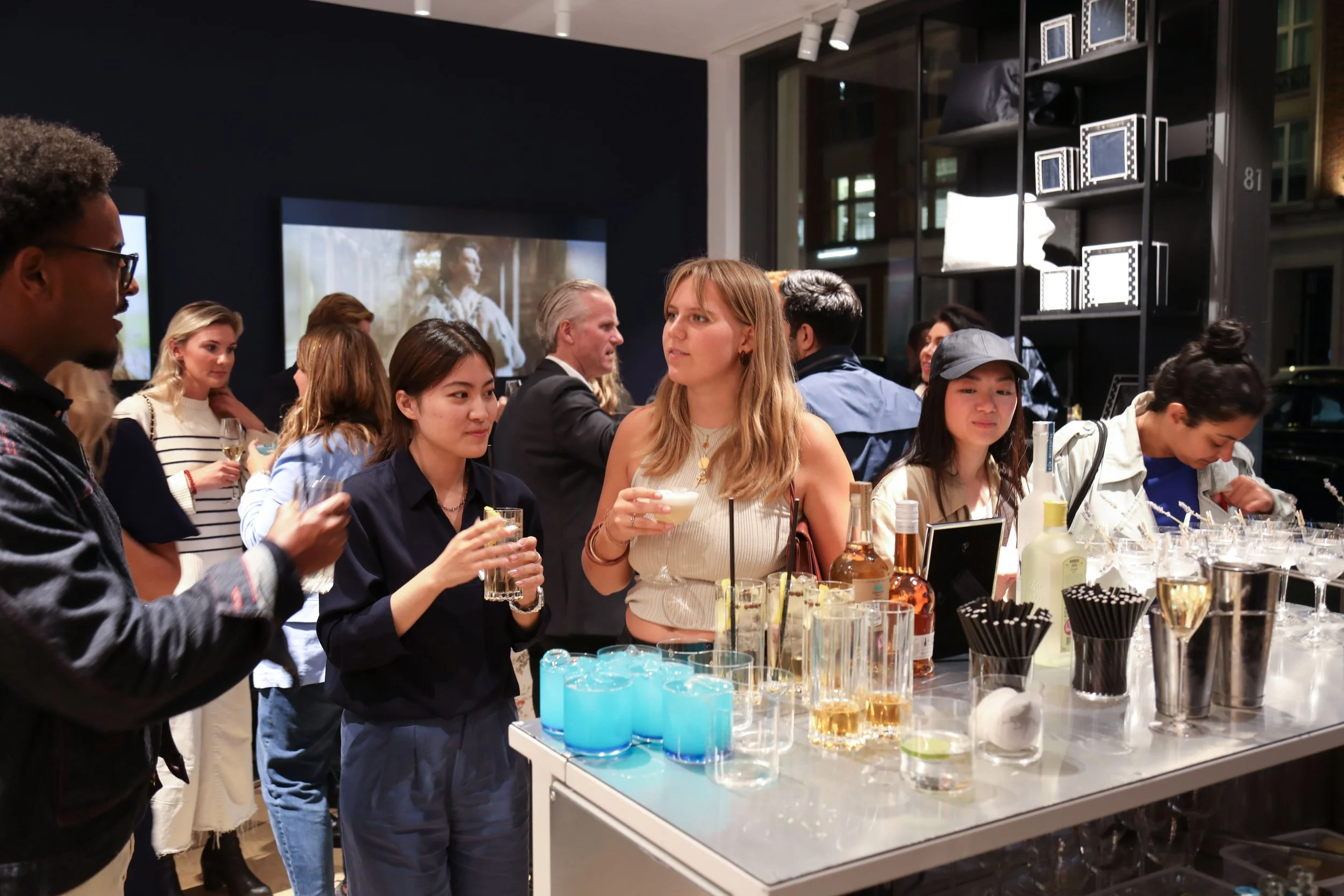 Guests networking around bespoke cocktail bar for corporate events in London.