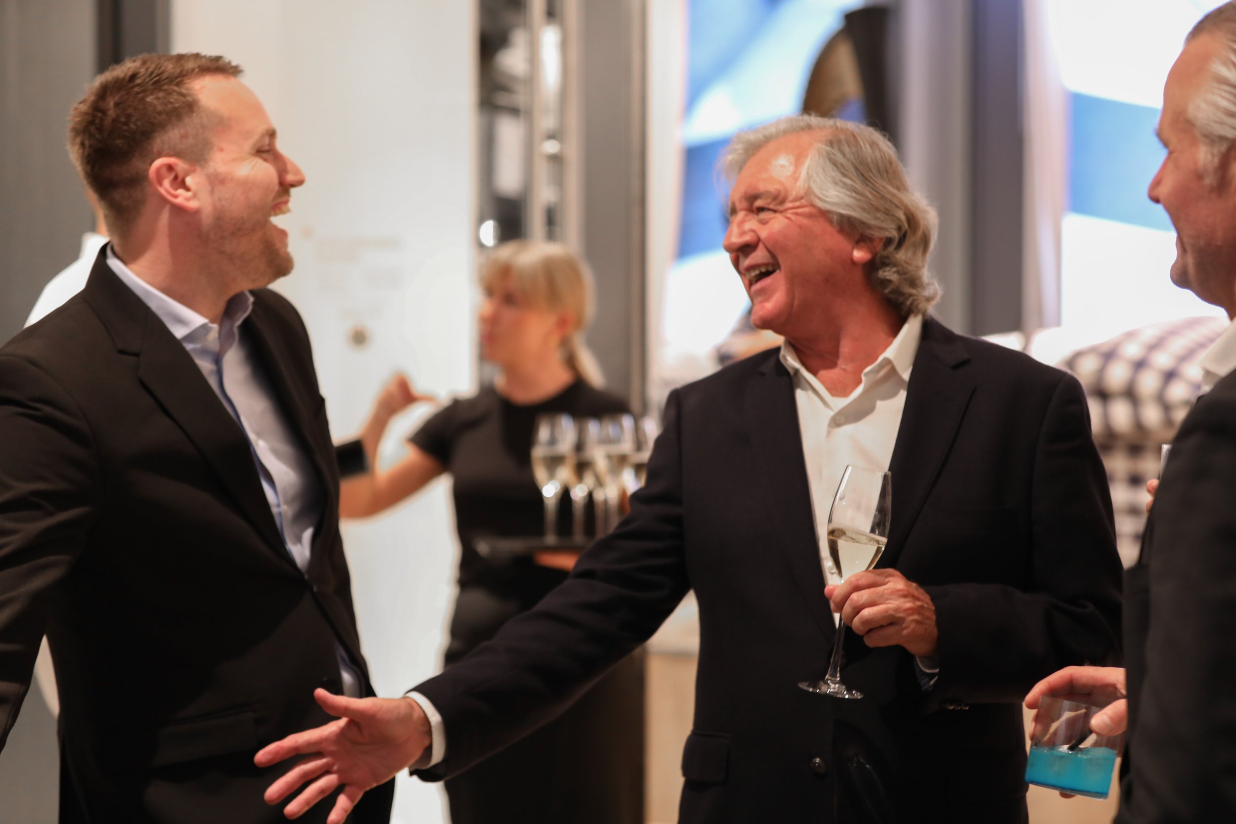 Friendly corporate mixologist creating a welcoming atmosphere at a premium London business event.