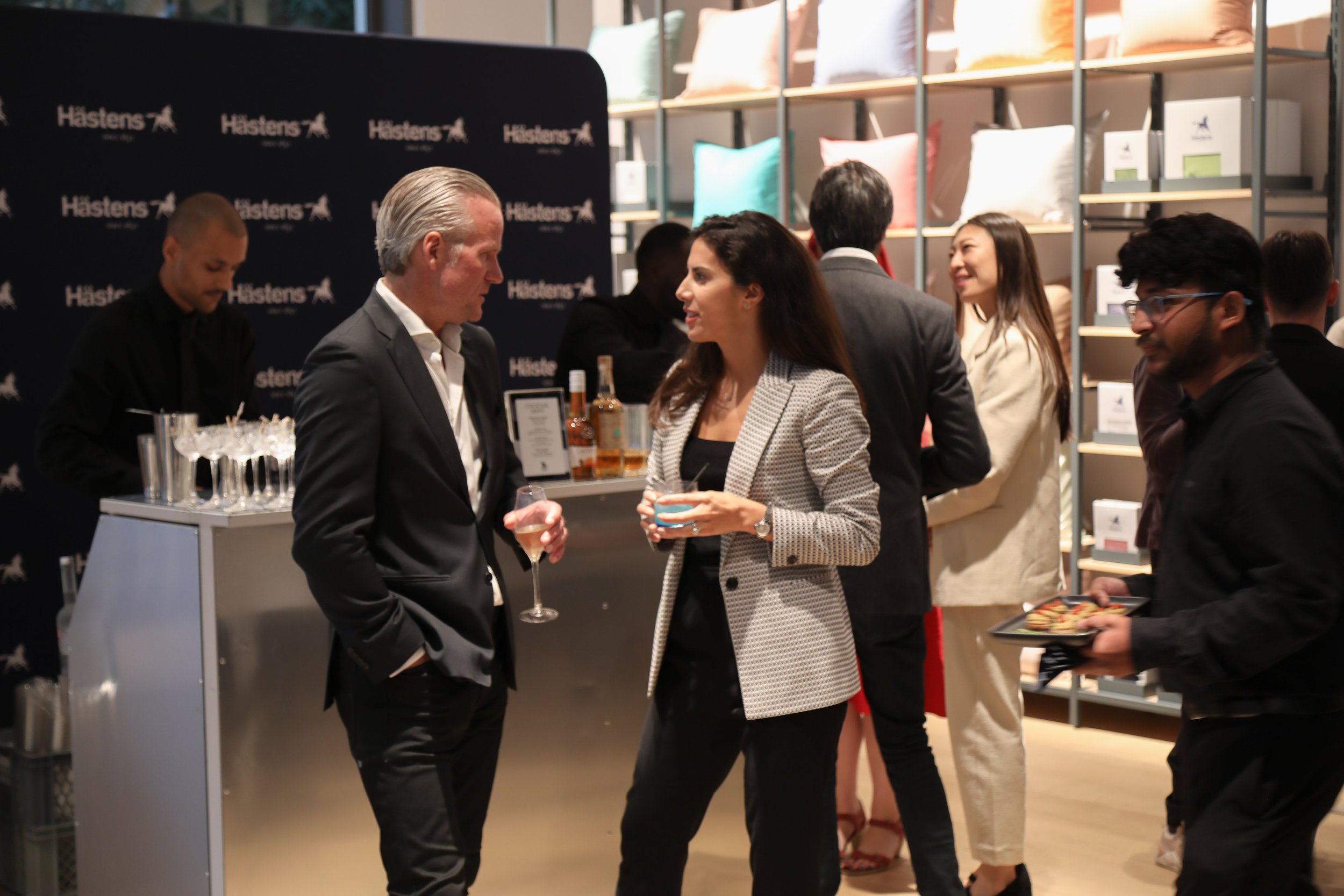Guests networking around a bespoke cocktail bar for corporate events after presentations finish.
