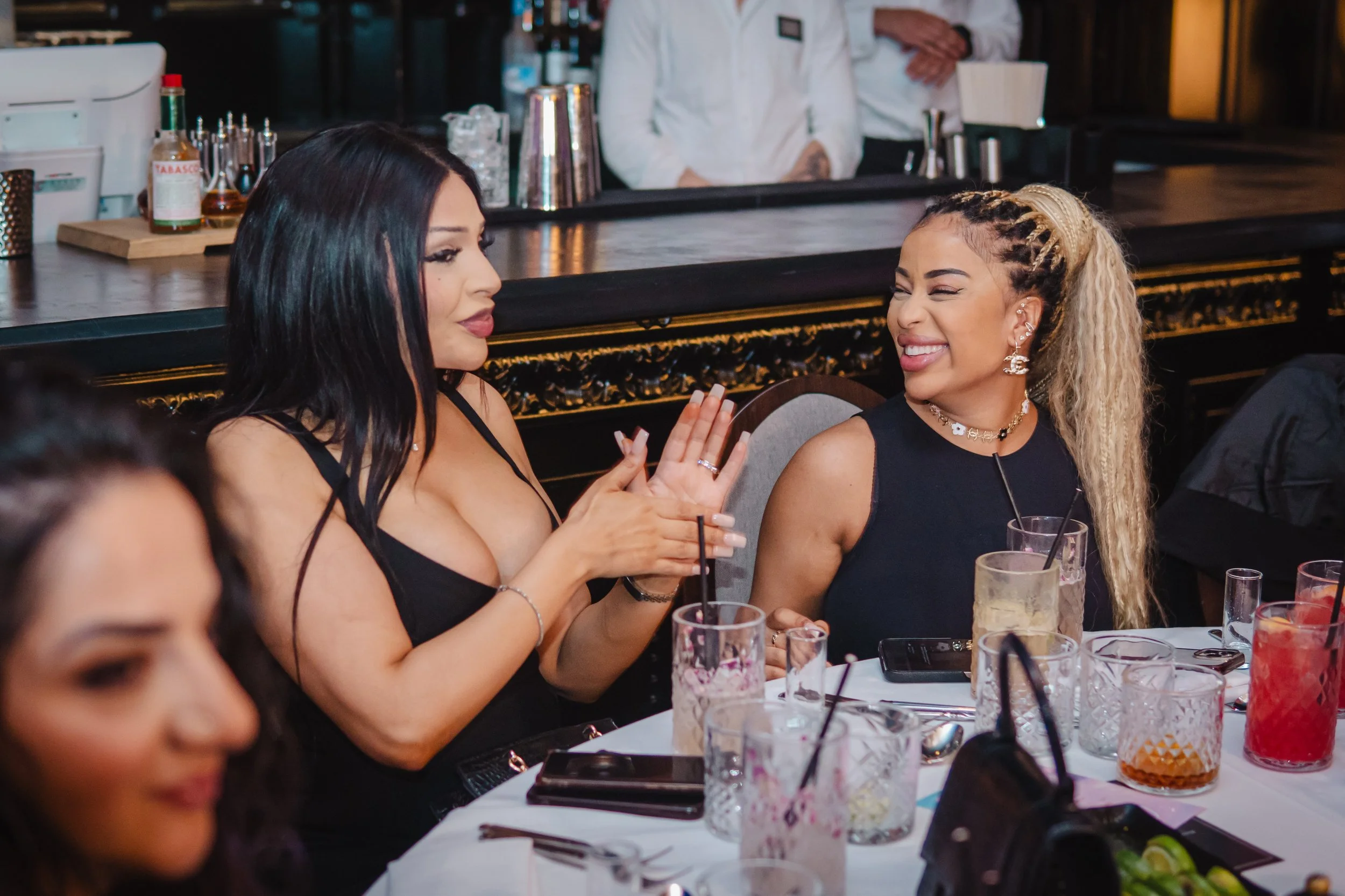 Guests enjoying cocktails from bartender for private event in intimate luxury setting.