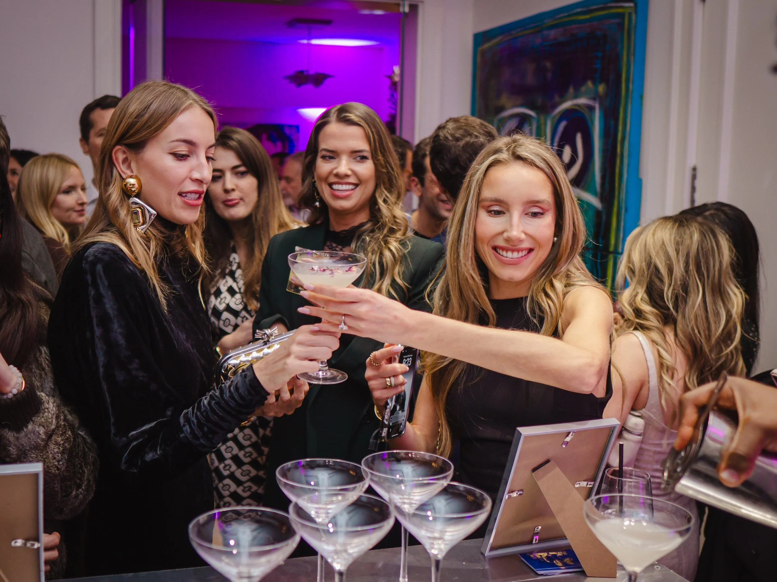 Private cocktail bartender helping guests connect around an elegant London home bar.