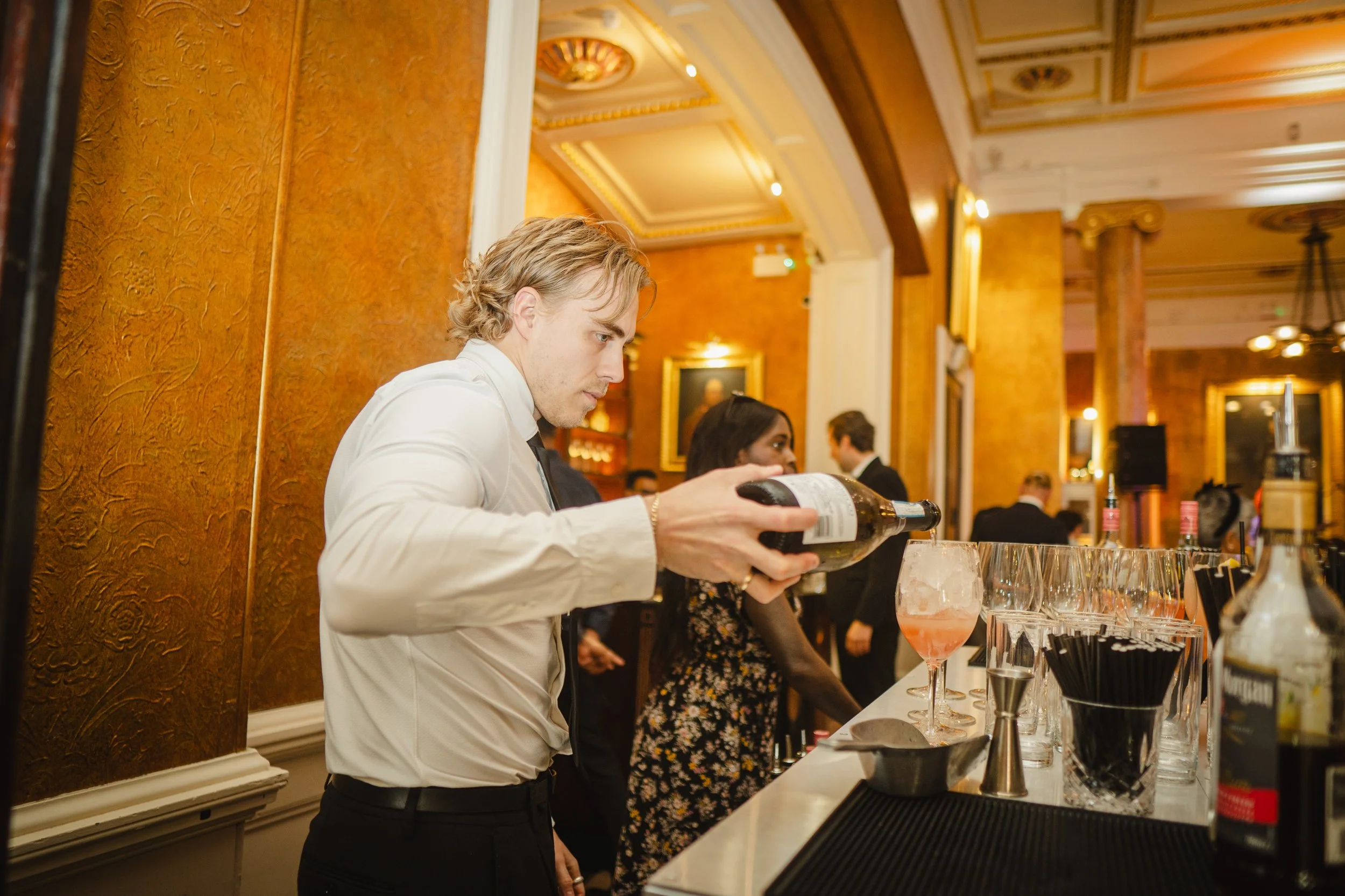 Professional wedding mixologist preparing bespoke cocktail at London luxury wedding.