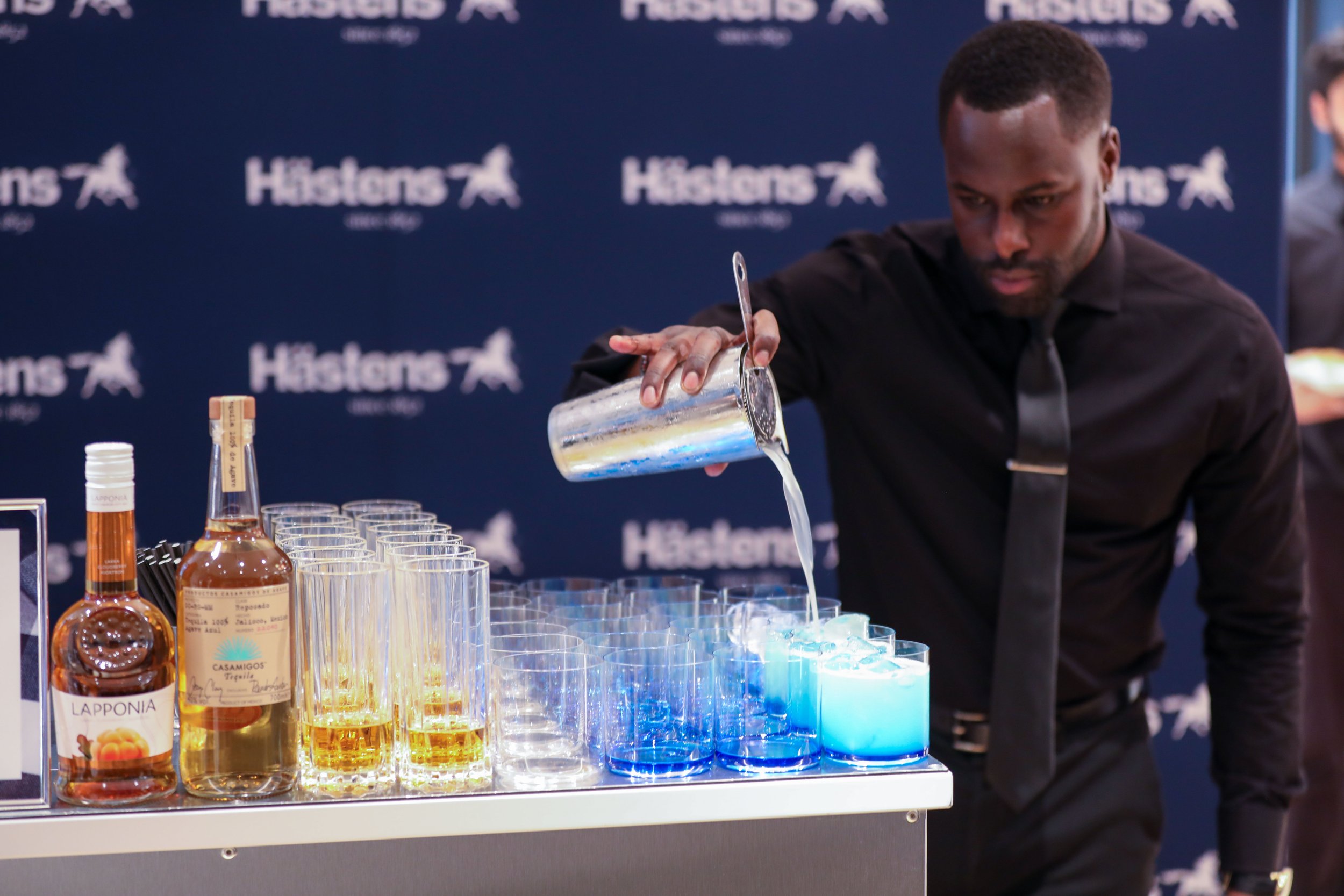 Corporate mixologist creating colour-themed branded cocktails at luxury corporate event.