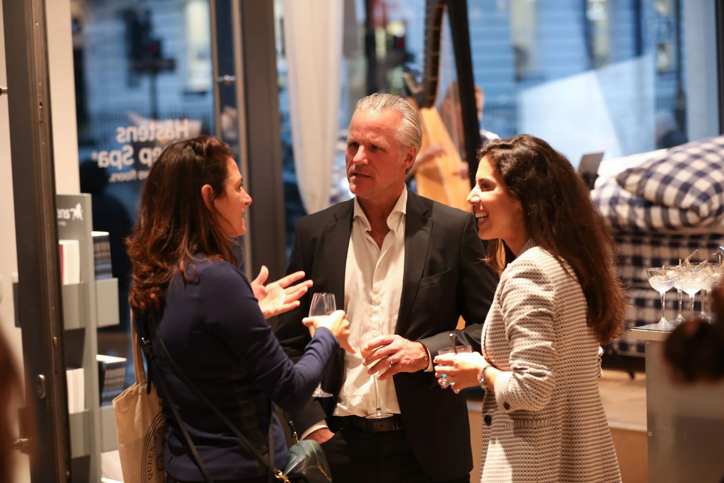 Guests networking around bespoke cocktail bar for corporate events after formal presentations.
