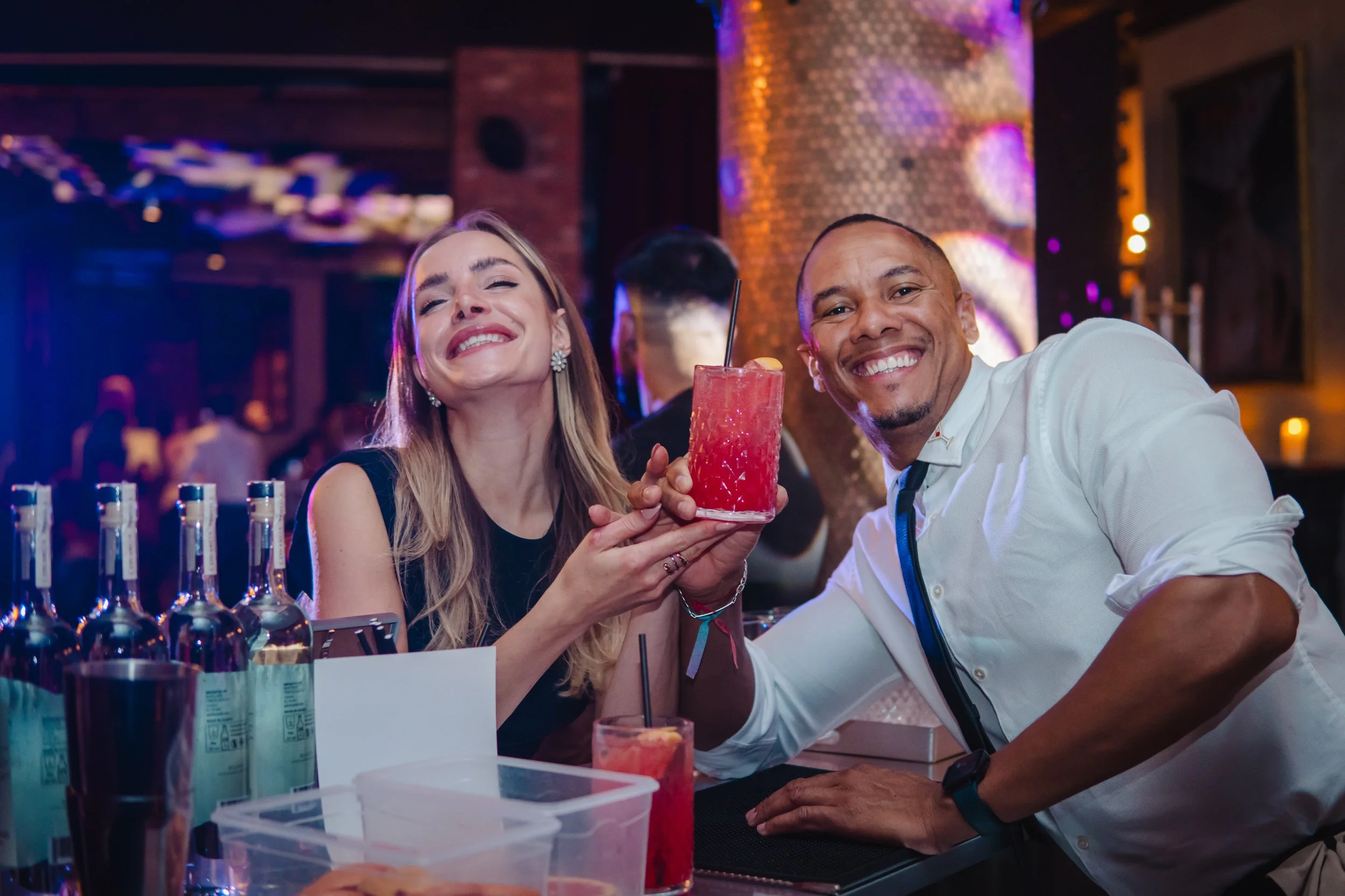 Guests enjoying cocktails from bartender for private event in refined home setting.