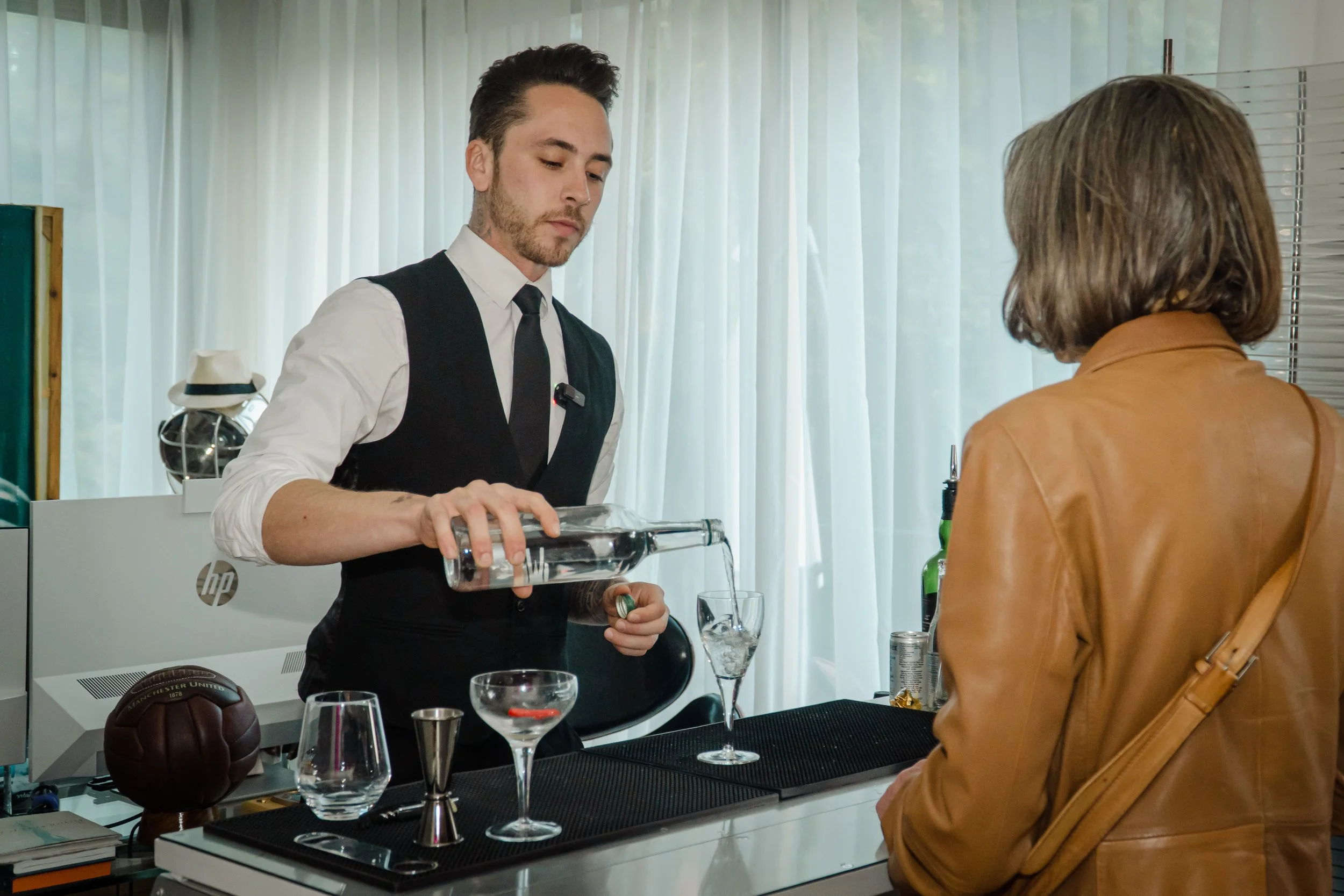 Bartender for private event London welcoming guests at a stylish house party.