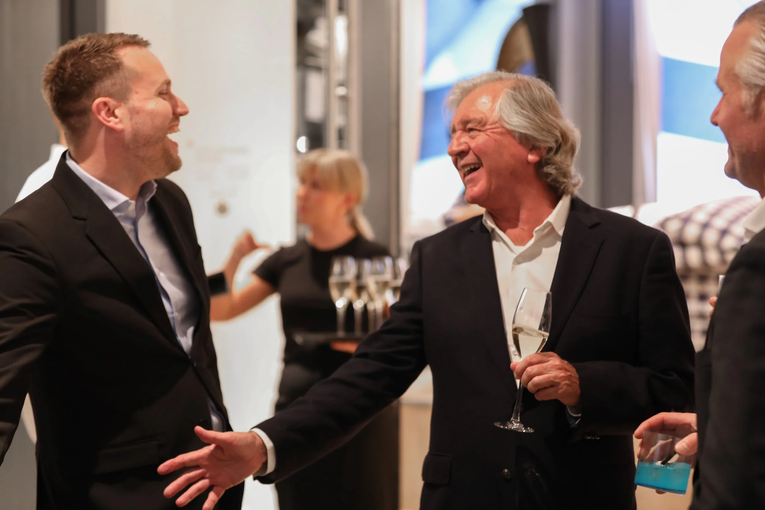 VIP clients networking around luxury cocktail bar at corporate event.