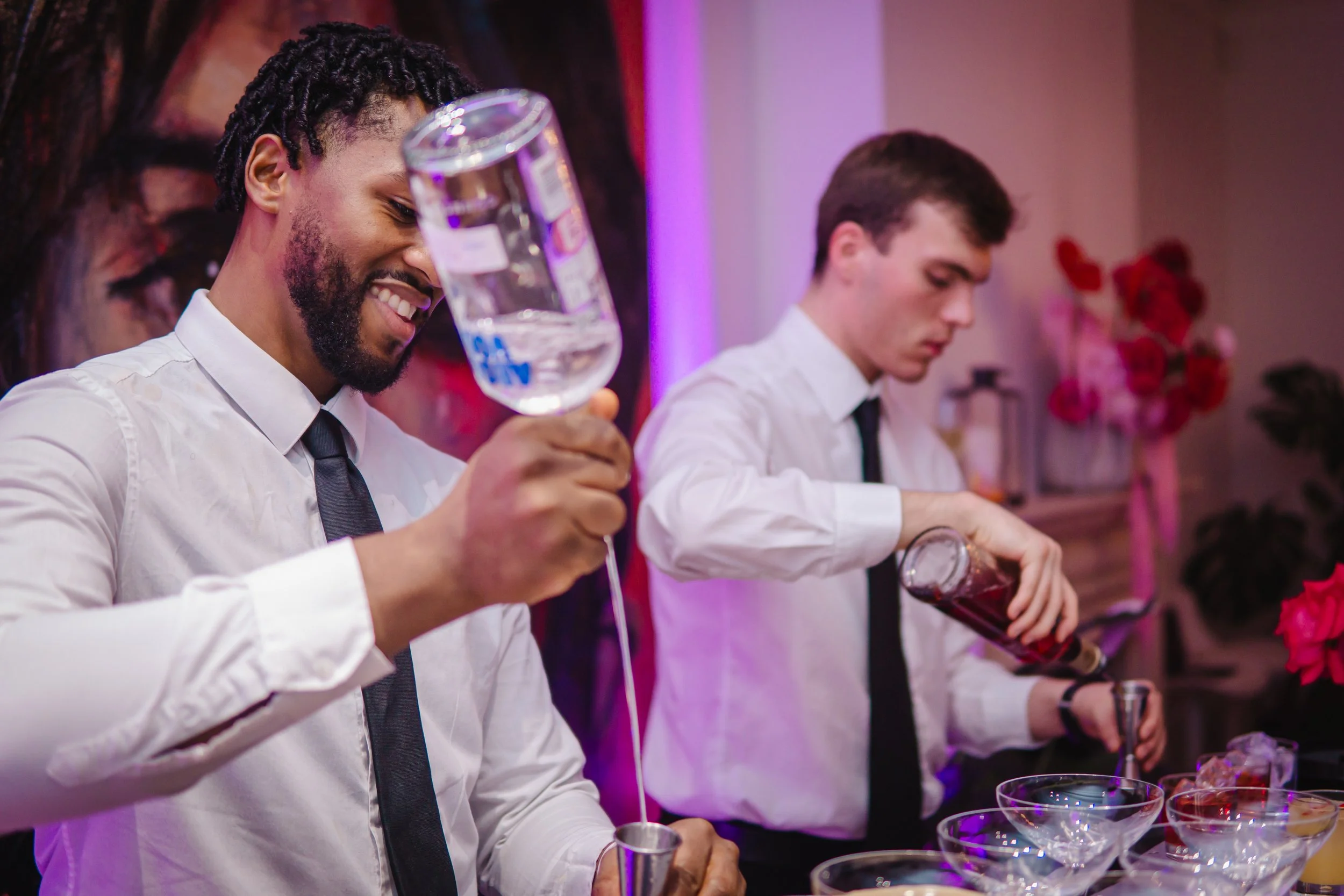 Friendly private cocktail bartender creating a welcoming atmosphere at an elegant London party.