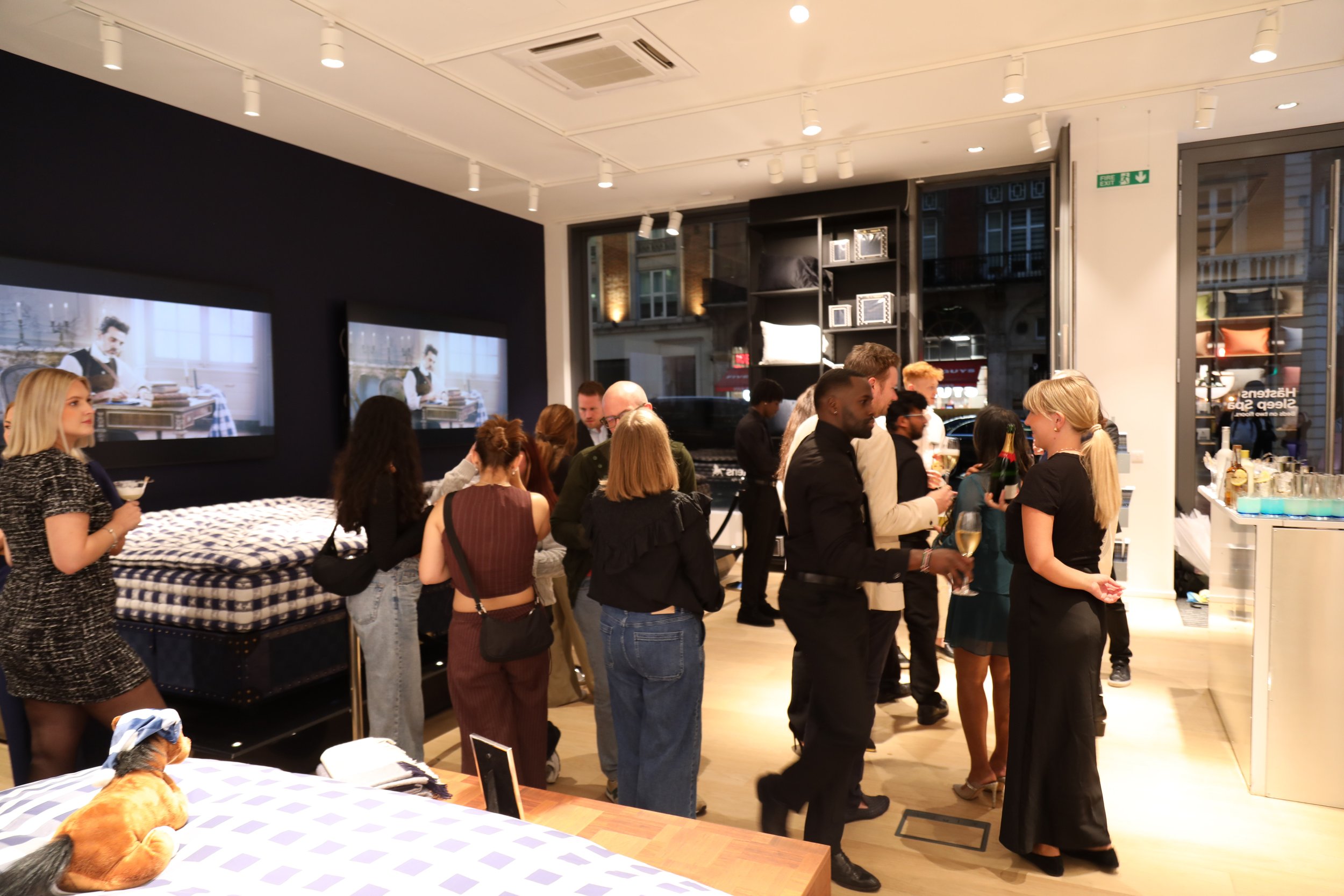 Guests networking around a bespoke cocktail bar for corporate events with elegant branded styling.