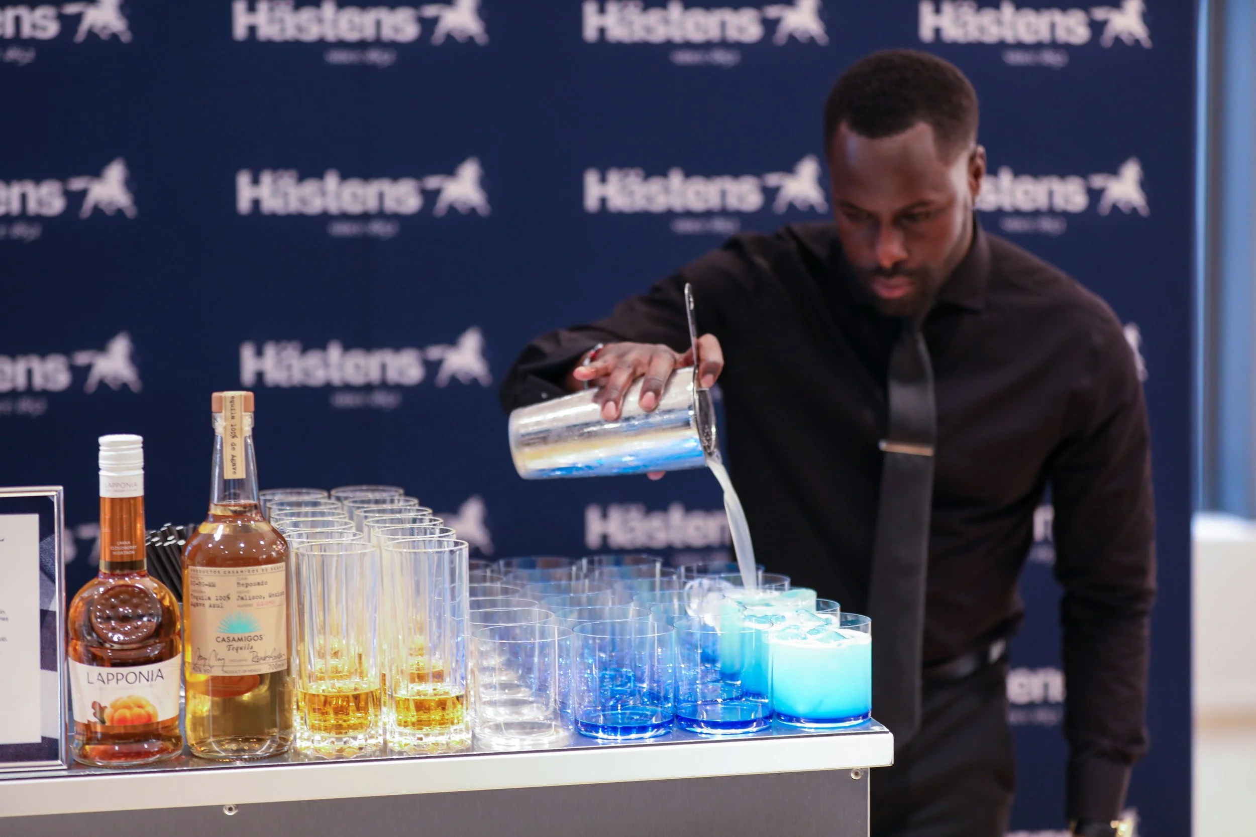 Corporate mixologist crafting premium cocktail at luxury corporate event.