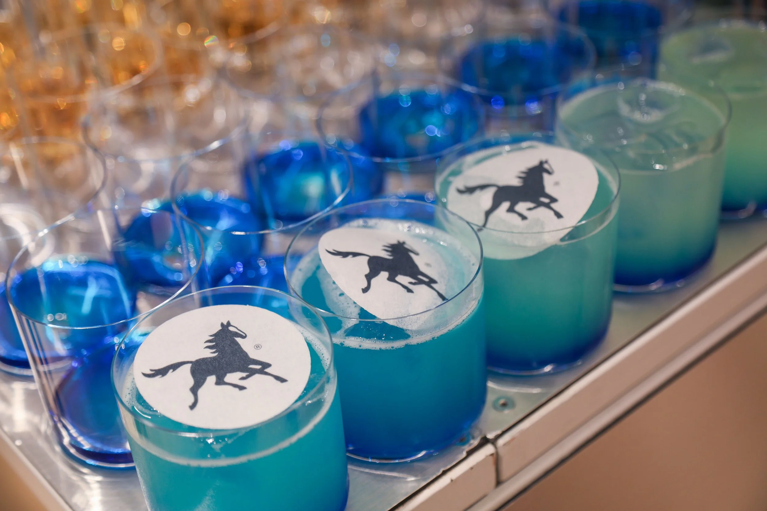 Corporate cocktail bar hire showcasing branded cocktails designed around company colours.
