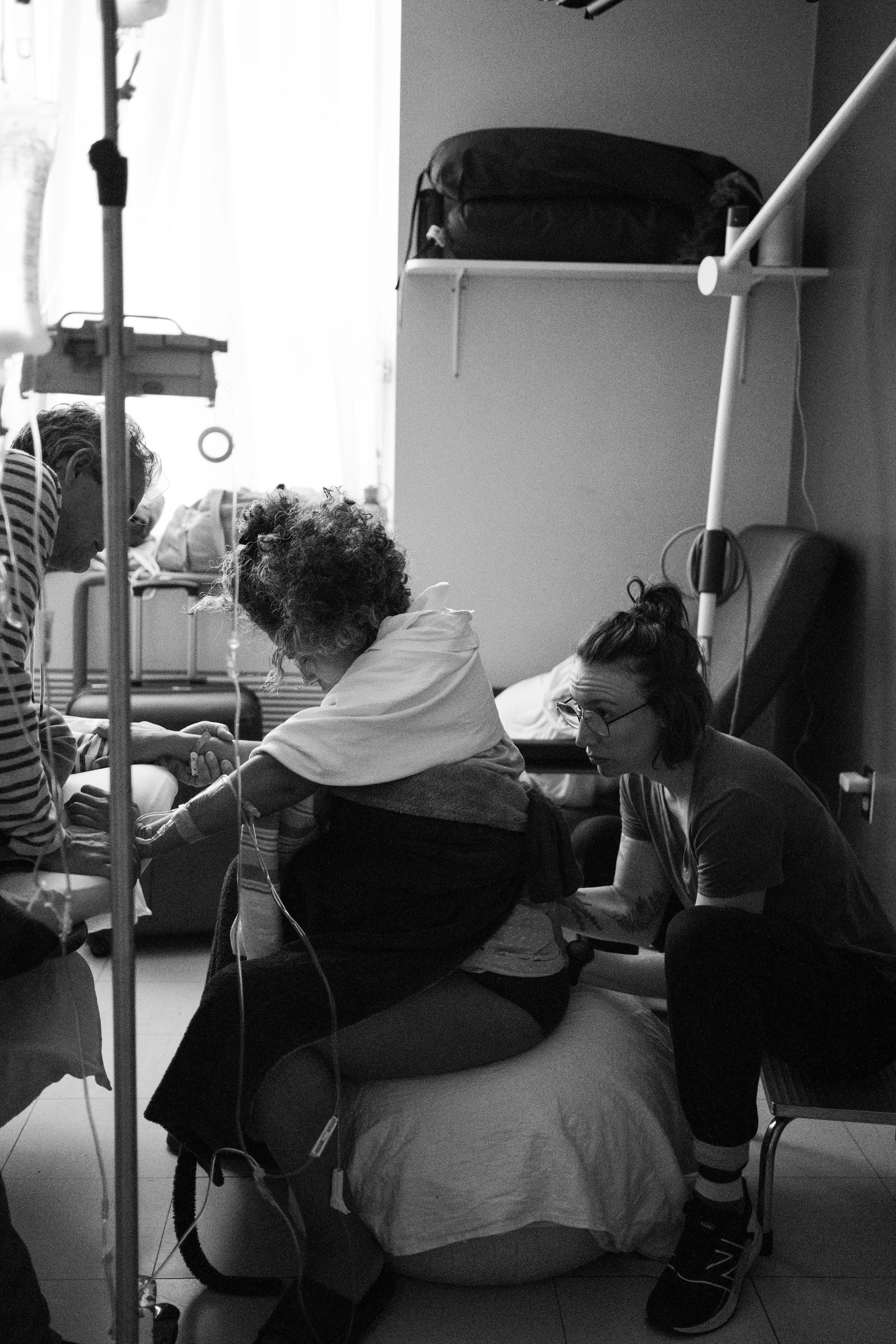 Accompagnate à la naissance qui aide une femme qui accouhement en lui fesant les points de pression.